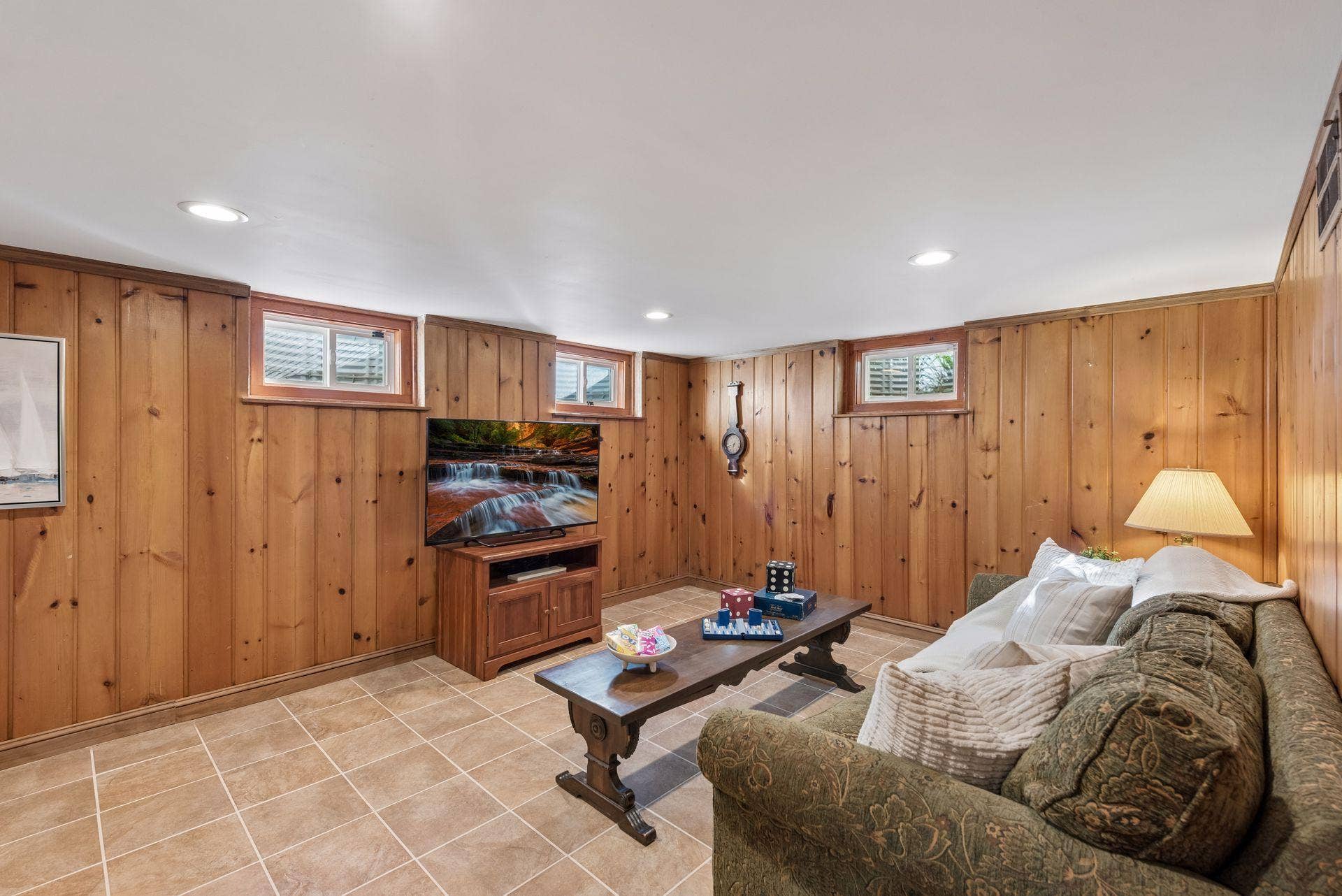 5212 Humboldt Avenue S, 49, Minneapolis, MN 55419 Lower-Level Family Room - Another view highlights the spacious lower-level family room with knotty-pine walls, tile flooring, recessed lighting, and multiple windows bringing in natural light.