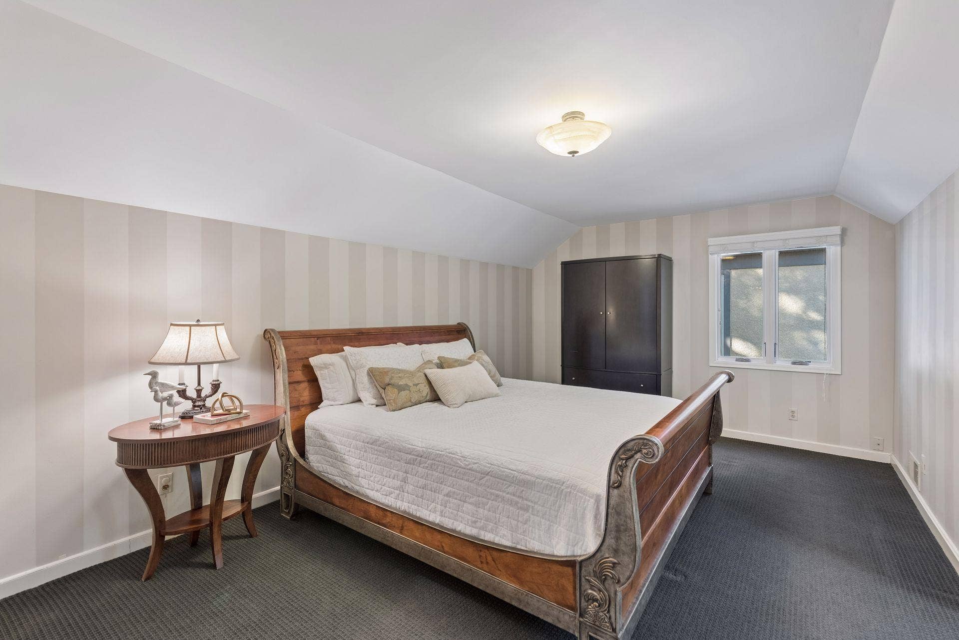 5212 Humboldt Avenue S, 49, Minneapolis, MN 55419 Upper-Level Bedroom - Spacious upper bedroom features a distinctive sloped ceiling, neutral paint striped walls, and room for a large bed and additional furniture.