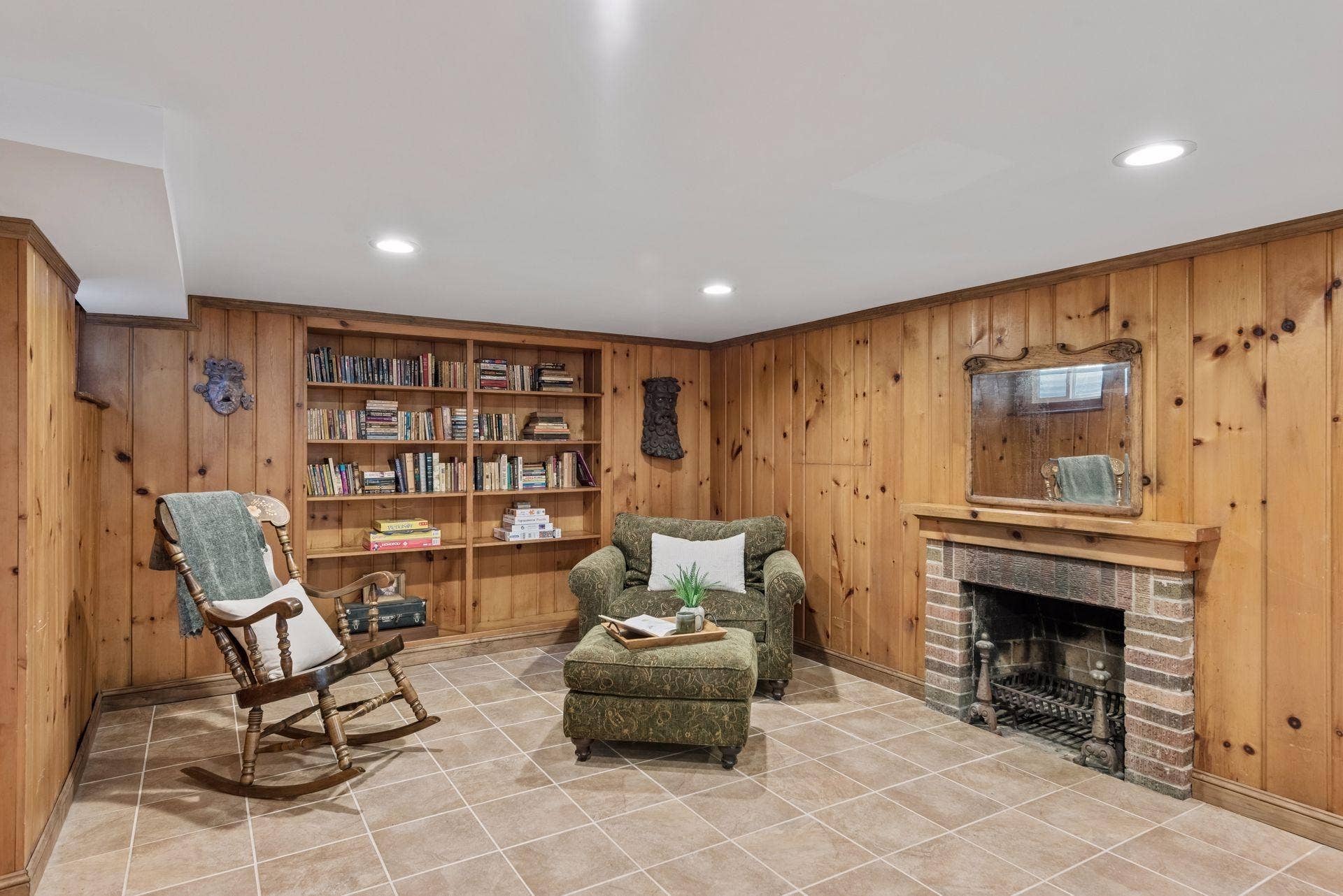5212 Humboldt Avenue S, 49, Minneapolis, MN 55419 Lower-Level Fireplace - A closer view highlights the brick fireplace, built-in bookshelves, knotty-pine walls, and dedicated sitting area in the lower-level family room.