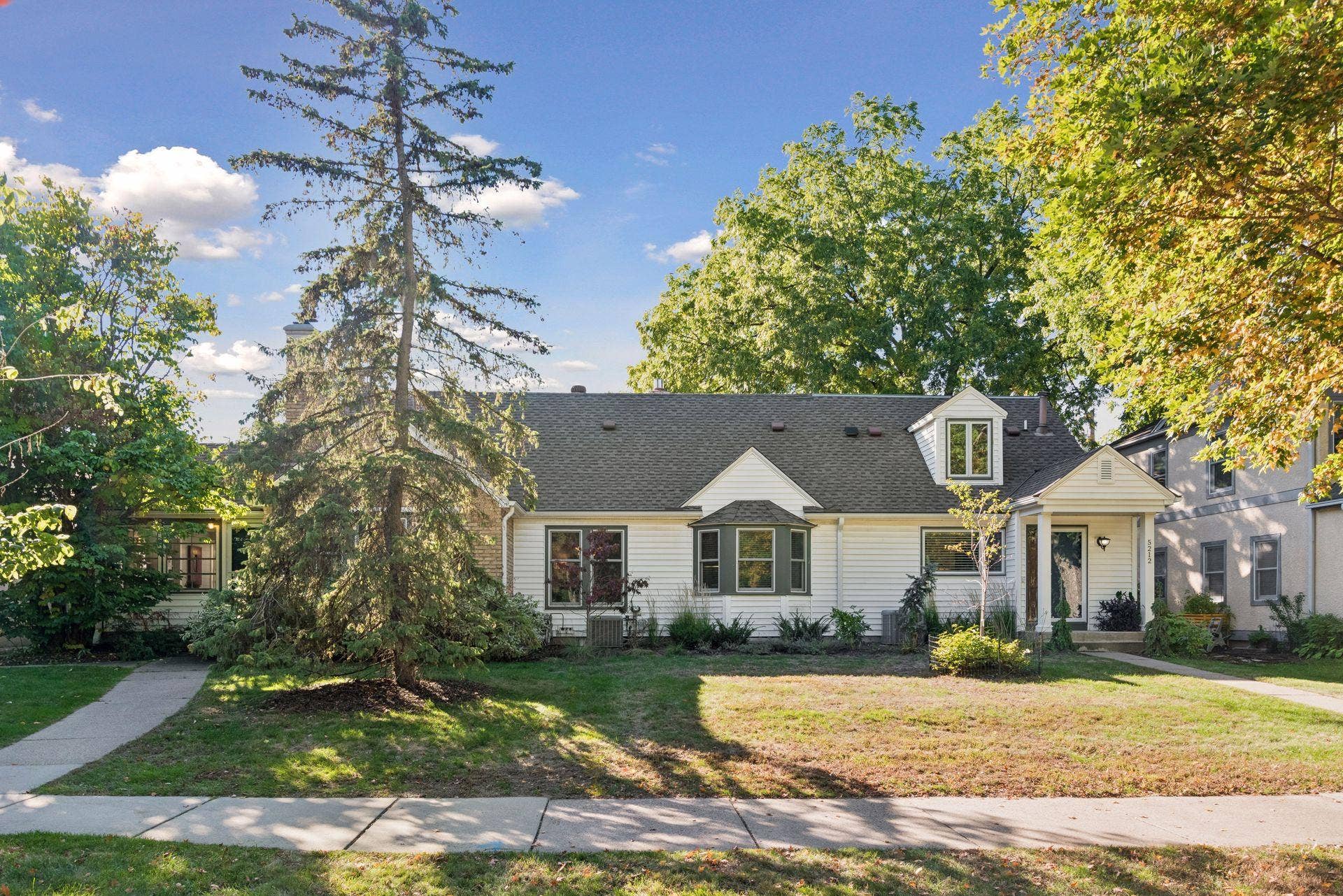 5212 Humboldt Avenue S, 49, Minneapolis, MN 55419 Front Exterior - Full front view highlights the homes broad footprint, mature trees, landscaped yard, dormer window, bay window, and welcoming covered entry.
