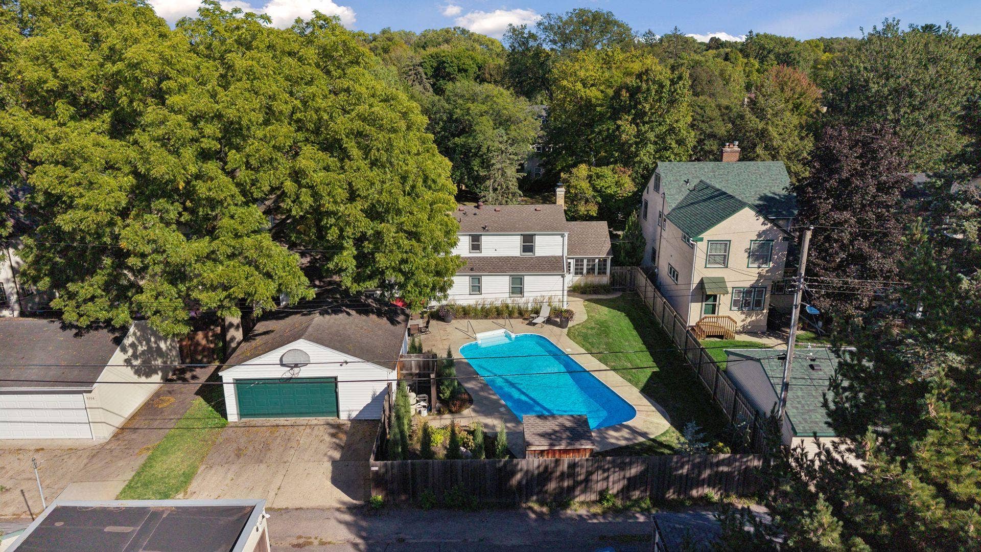 5212 Humboldt Avenue S, 49, Minneapolis, MN 55419 Backyard Aerial - Elevated rear view showcases the in-ground swimming pool, surrounding patio, fenced backyard, detached 2-car garage, and the homes rear elevation.