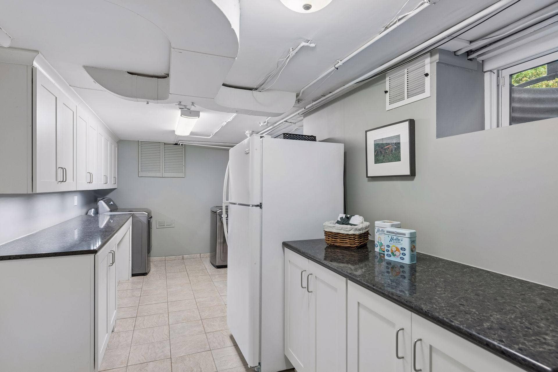 5212 Humboldt Avenue S, 49, Minneapolis, MN 55419 Laundry Room - Well-organized lower-level laundry area offers extensive cabinetry, long countertops, tile flooring, utility sink, and space for an additional refrigerator.