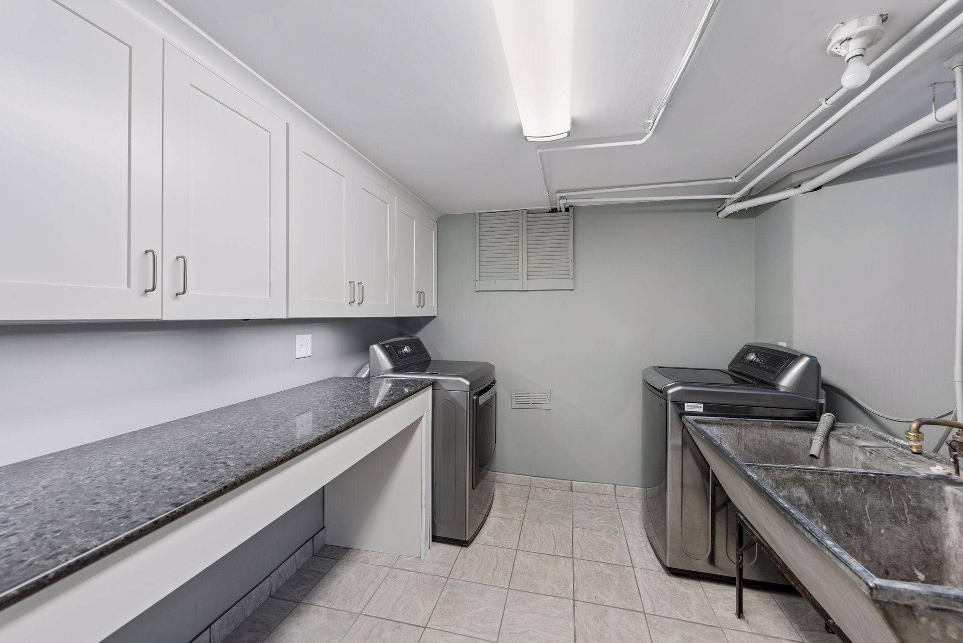 5212 Humboldt Avenue S, 49, Minneapolis, MN 55419 Laundry Room - A second view highlights the generous cabinet and counter space, washer and dryer, utility sink, and bright overhead lighting in the lower-level laundry area.