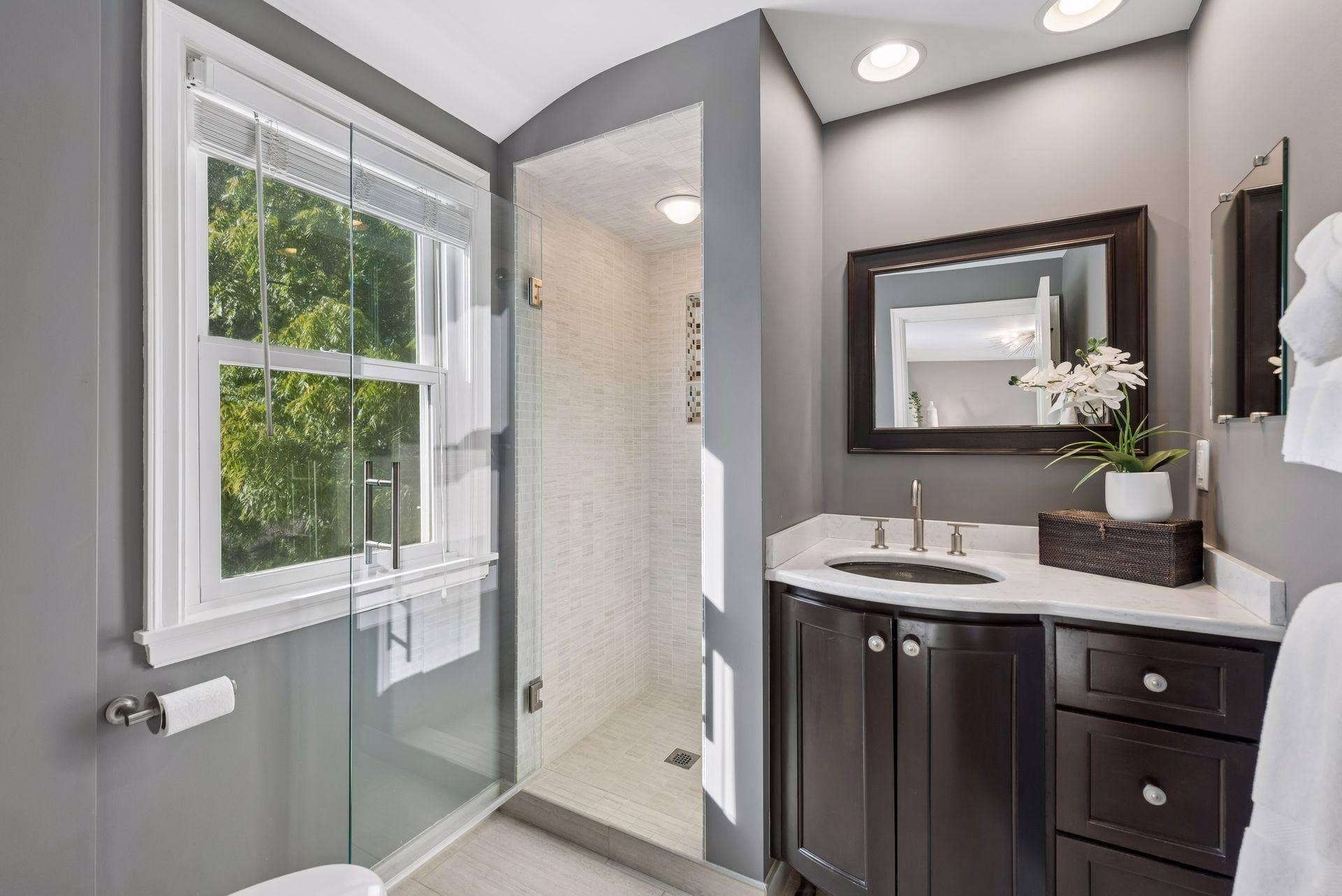 5212 Humboldt Avenue S, 49, Minneapolis, MN 55419 Primary Bathroom - Updated primary bath features a glass-enclosed tiled shower, dark wood vanity with light countertop, recessed lighting, and natural light from the window.