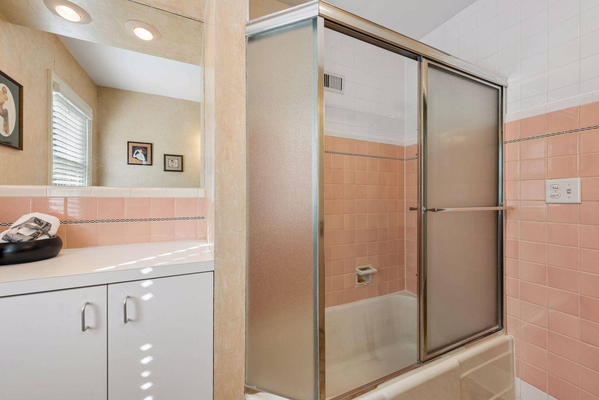 5212 Humboldt Avenue S, 49, Minneapolis, MN 55419 Full Bathroom - A closer look at the tub/shower highlights the bathroom's classic pink and white tilework, glass enclosure, and additional built-in storage.