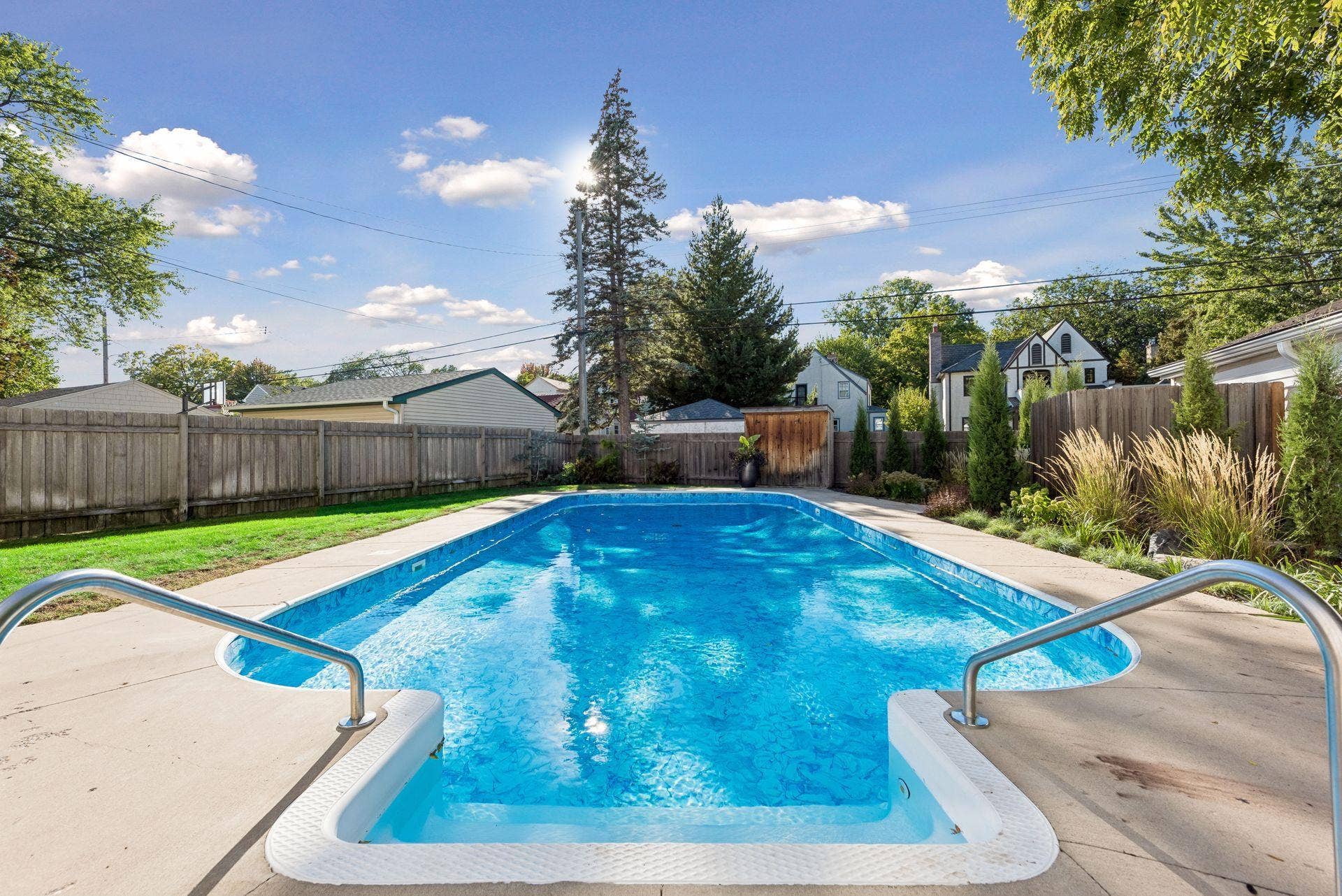 5212 Humboldt Avenue S, 49, Minneapolis, MN 55419 In-Ground Pool - A view from the pool steps highlights the pools generous size, surrounding concrete deck, mature landscaping, and privacy fencing.