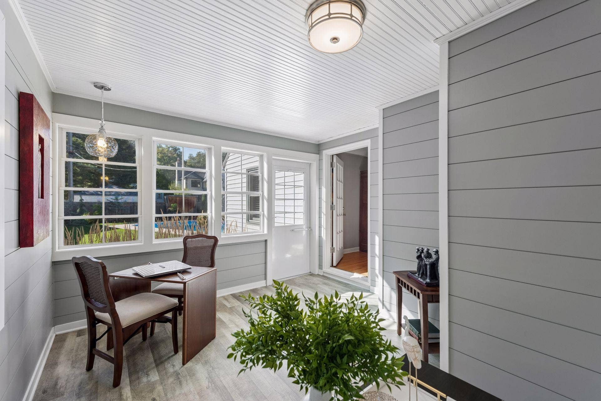 5212 Humboldt Avenue S, 49, Minneapolis, MN 55419 Sunroom - Another view highlights the sunrooms abundant windows, beadboard ceiling, paneled walls, and direct connection to the living room and backyard, with views toward the pool.