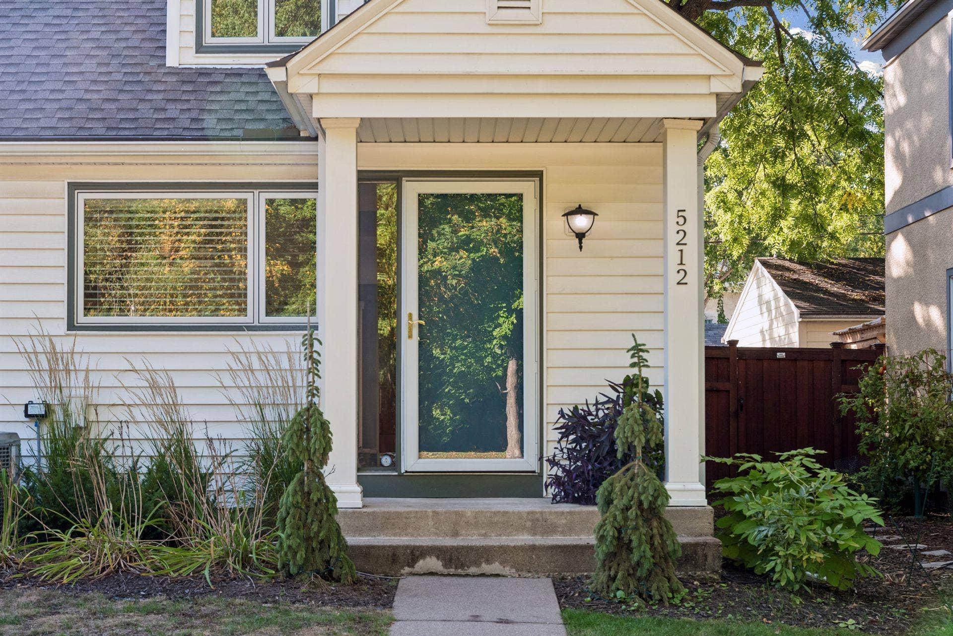 5212 Humboldt Avenue S, 49, Minneapolis, MN 55419 Front Entry - Covered front entry at 5212 Humboldt Ave S features a storm door, sidelight, exterior lighting, and landscaping that creates a welcoming approach.