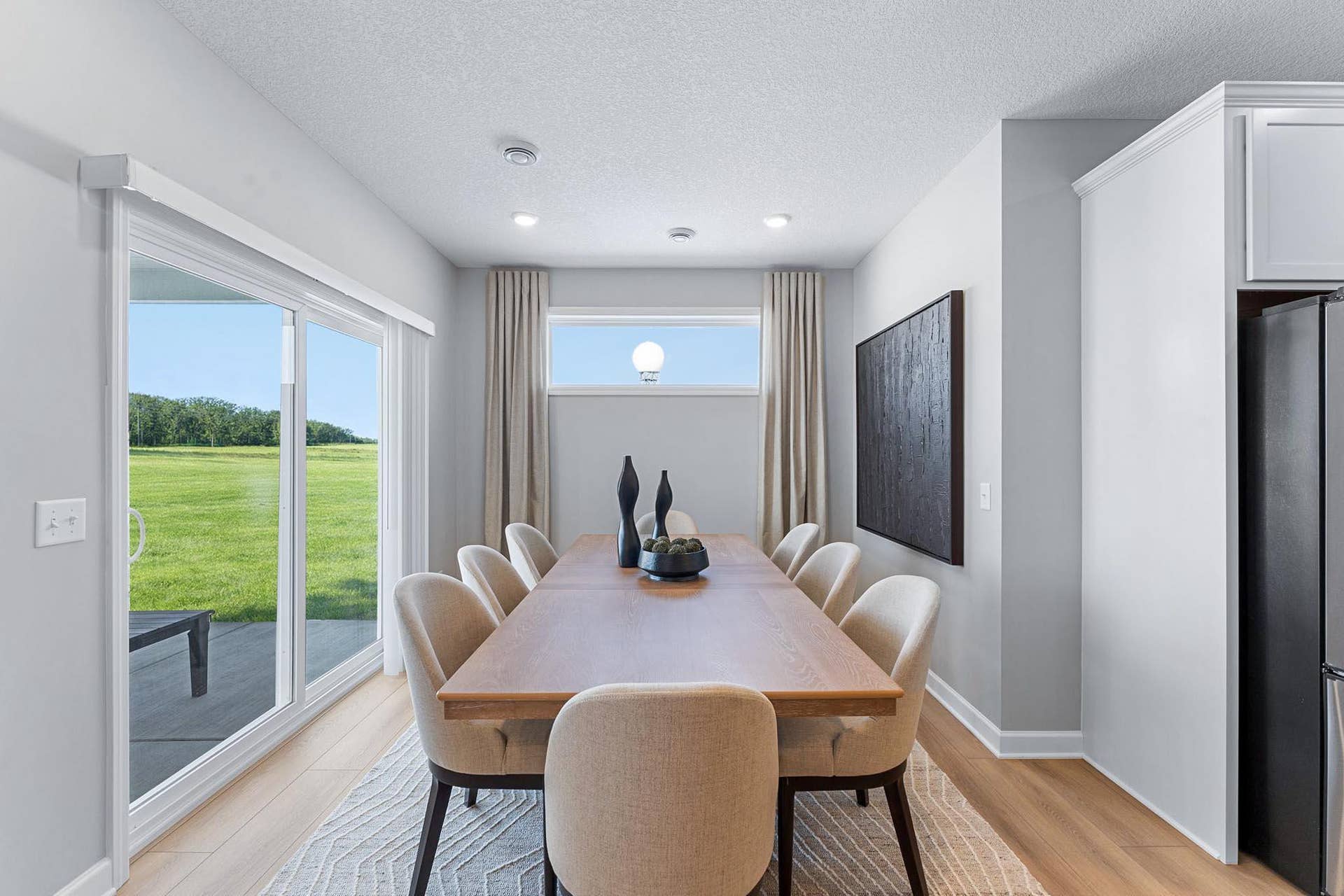 5222 Long Pointe Bay, Woodbury, MN 55129 Situated in front of glass sliders, this dining room provides the perfect place for sun-dappled meals that can venture out to the covered patio.