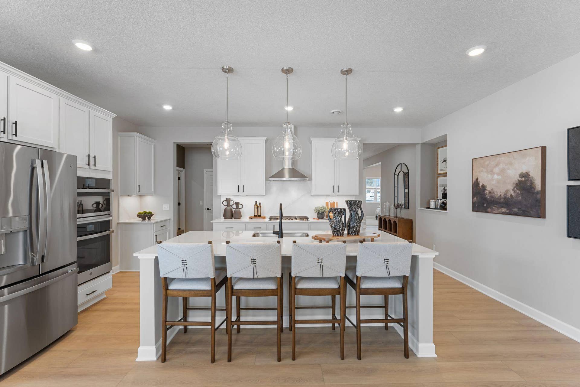 5222 Long Pointe Bay, Woodbury, MN 55129 At the focal point of this modern kitchen is an inviting center island that doubles as a breakfast bar, surrounded by gleaming quartz countertops and a high-end wall oven to craft delicious meals of all sizes.