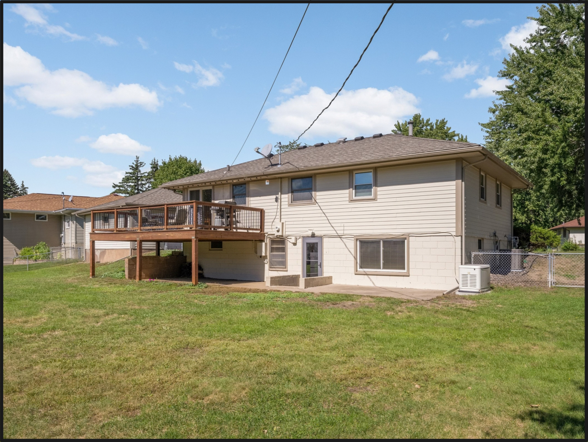 Spacious deck and yard featuring a walkout basement and lower patio