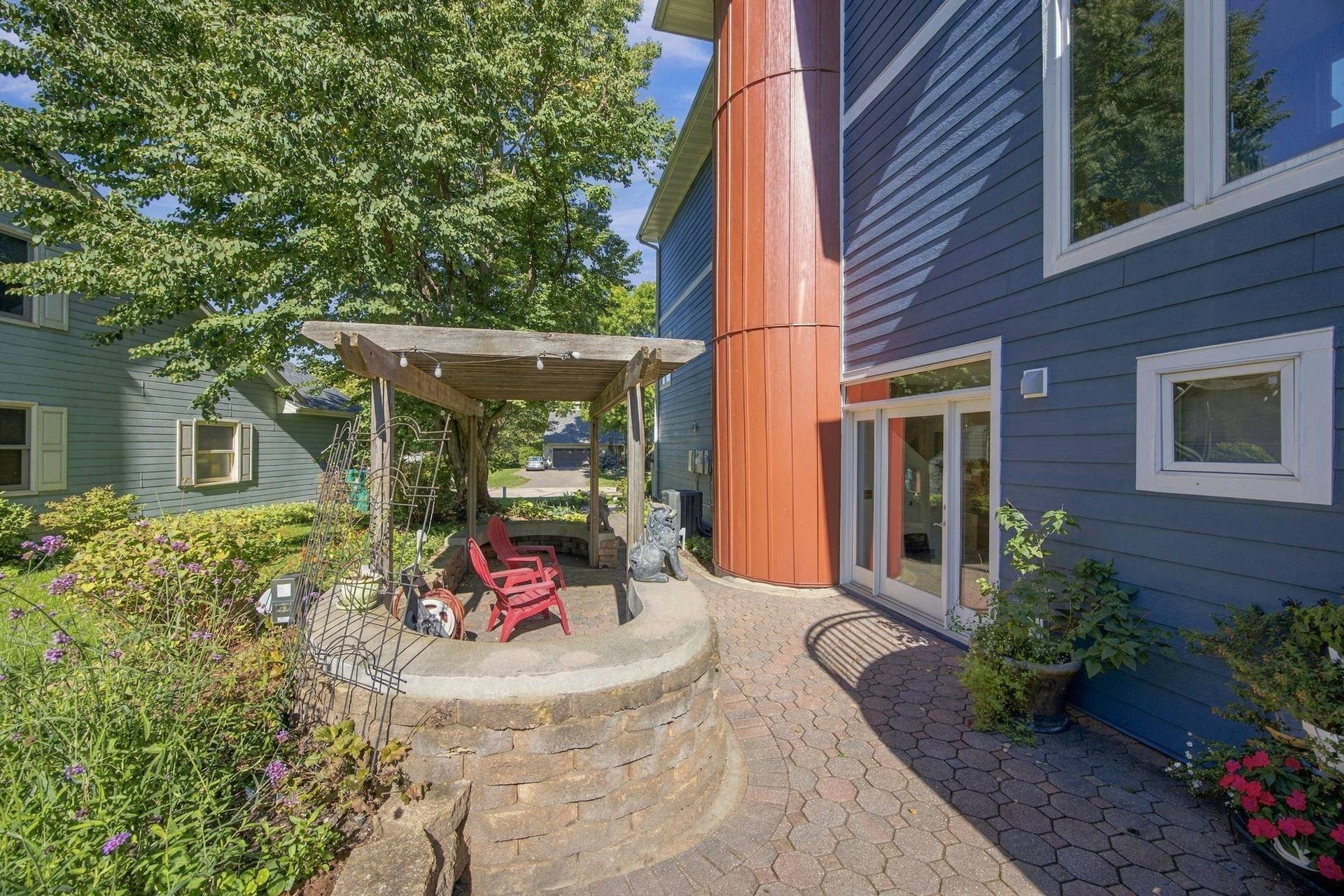 Striking entry with pergola paver courtyard off the entry and paver sidewalks leading to driveway and pool.