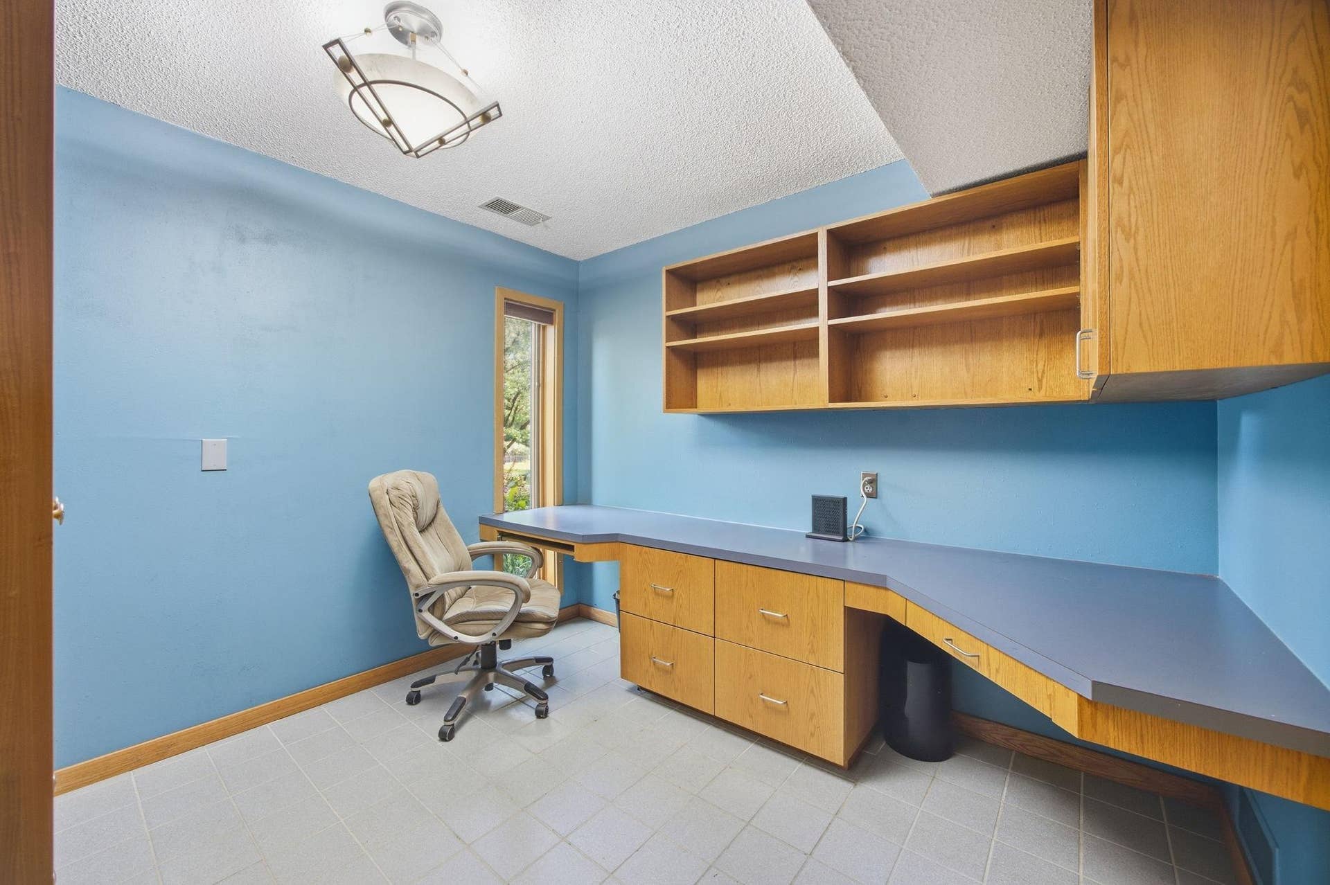 33-   Office with built in desk with shelving and cabinetry. Tile floor.