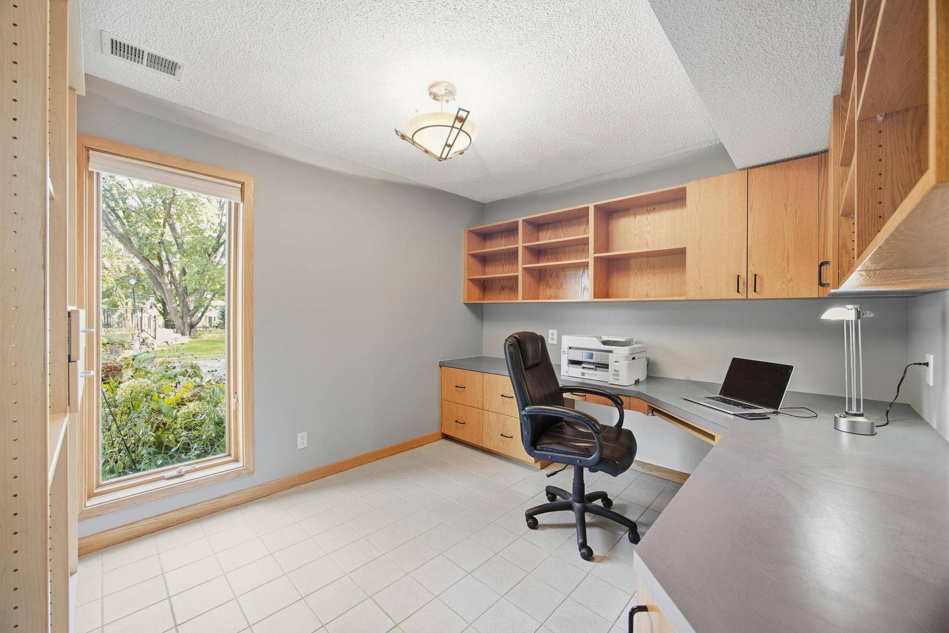 34-  Office with tile floor and large windows with built in desk and shelving.