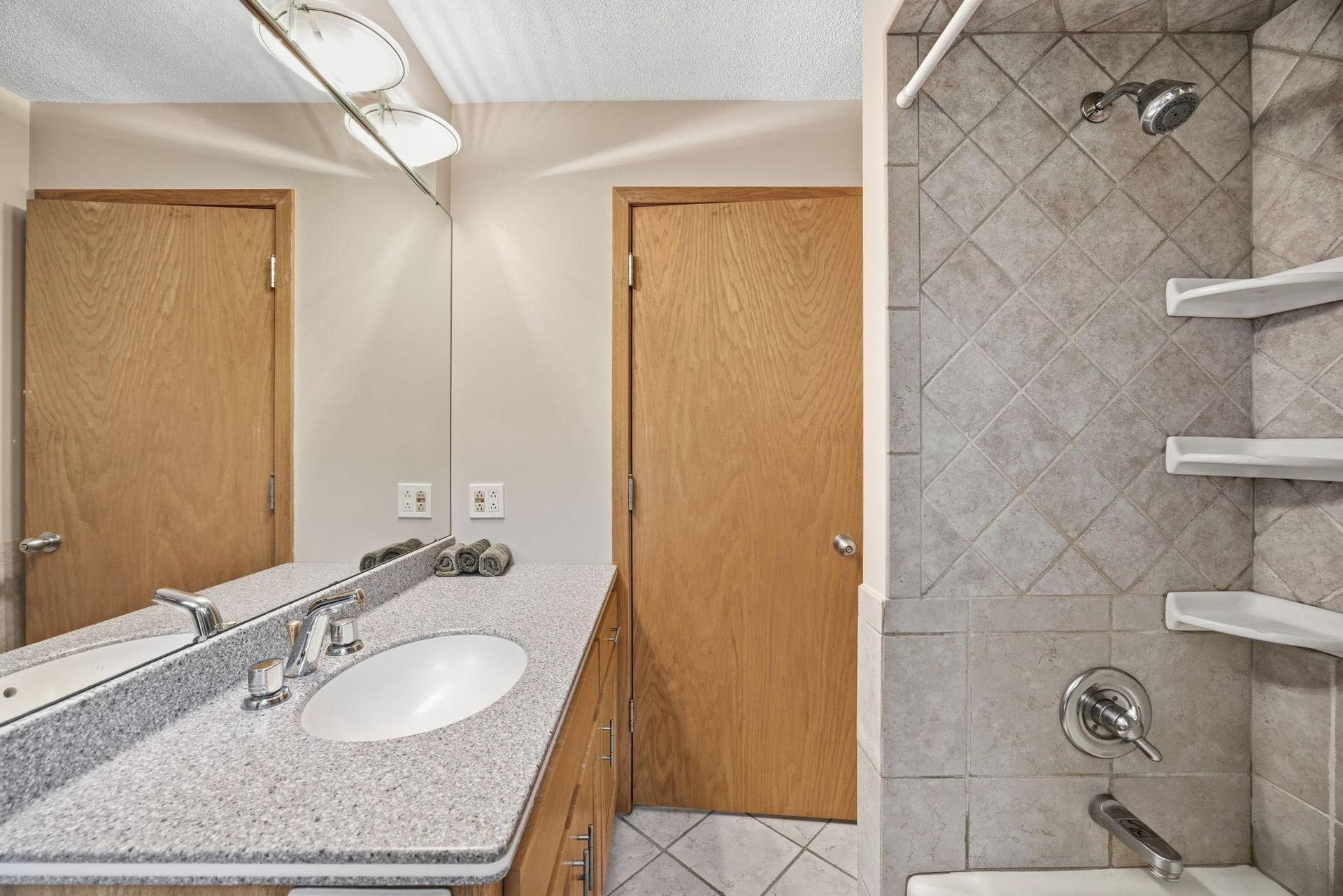 29- Upper level full bath with Corian countertops and tile surround.