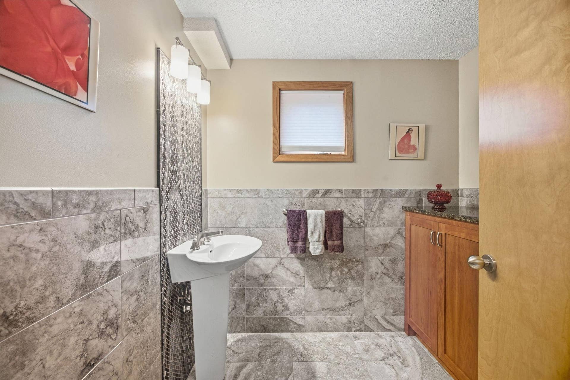 35-  1/2 bath off of the entry 1/2 wall tiling and built in cabinetry with granite top.