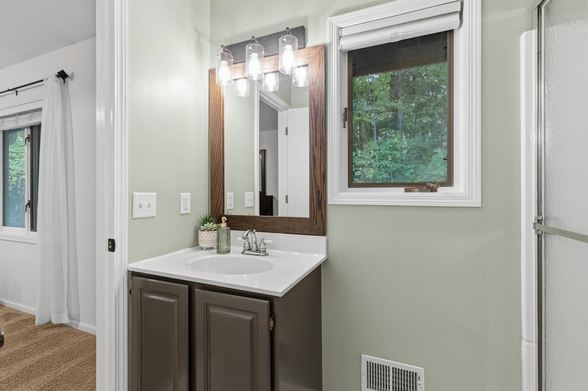 15469 Fish Point Road SE, Prior Lake, MN 55372 Pocket door access to the additional bath which includes a shower with glass doors, enameled vanity cabinet, natural light and access to the master bedroom!