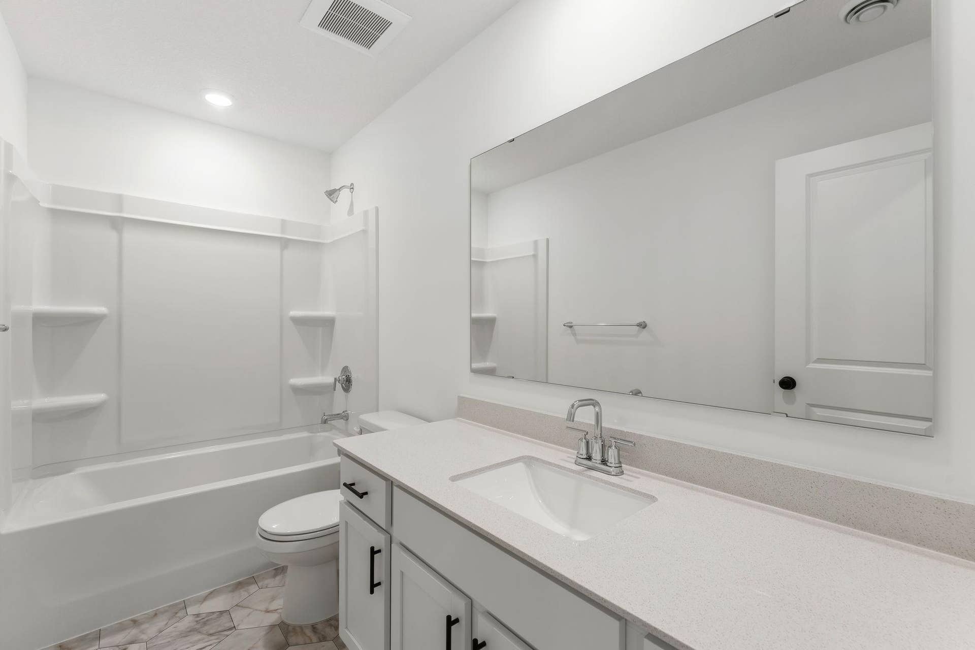 A full-sized bathroom on the second floor comes well-equipped with a generously sized quartz-topped vanity and a combination shower and tub to maximize the interior space.