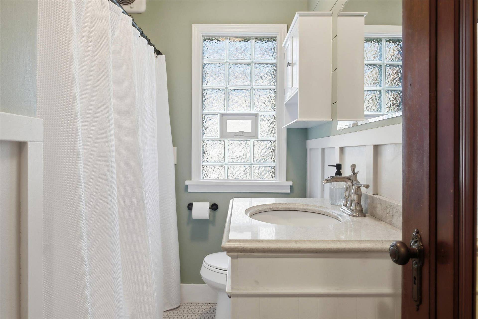 1118 Livingston Avenue, West Saint Paul, MN 55118 Updated full bathroom with a glass block window, newer vanity, mirror, faucet and fixtures.