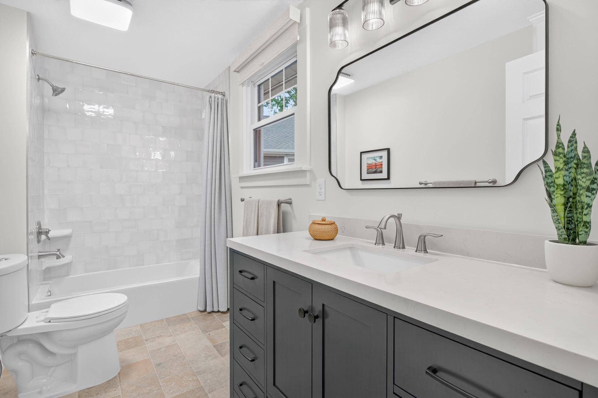 1835 Stillwater Street, White Bear Lake, MN 55110 The beautifully renovated secondary bath pairs heated tile floors with a thoughtfully tiled tub surround and elegant quartz-topped vanity.
