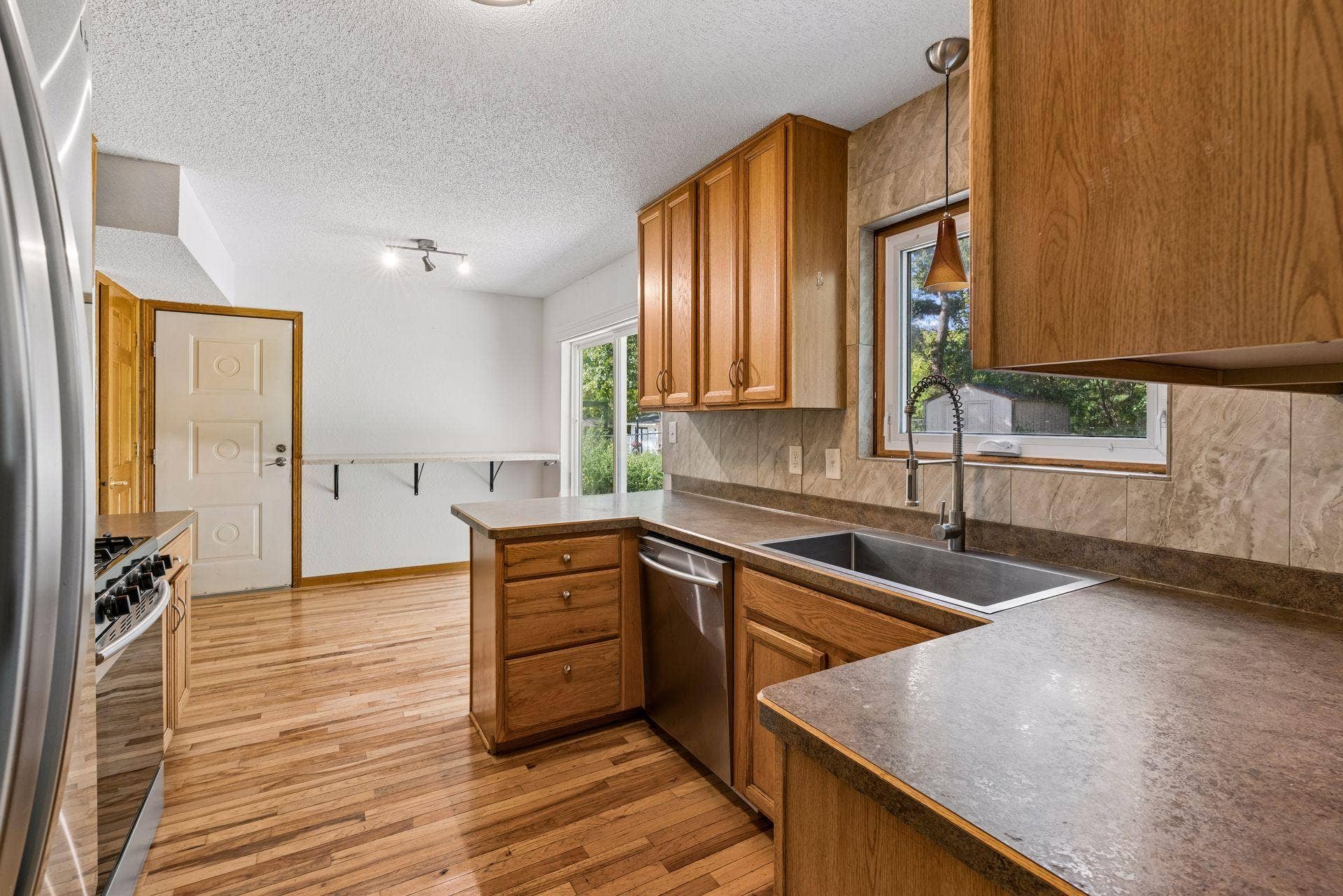 2841 Riviera Drive N, White Bear Lake, MN 55110 Kitchen with wood cabinetry, stainless steel appliances, and an adjoining casual dining area.