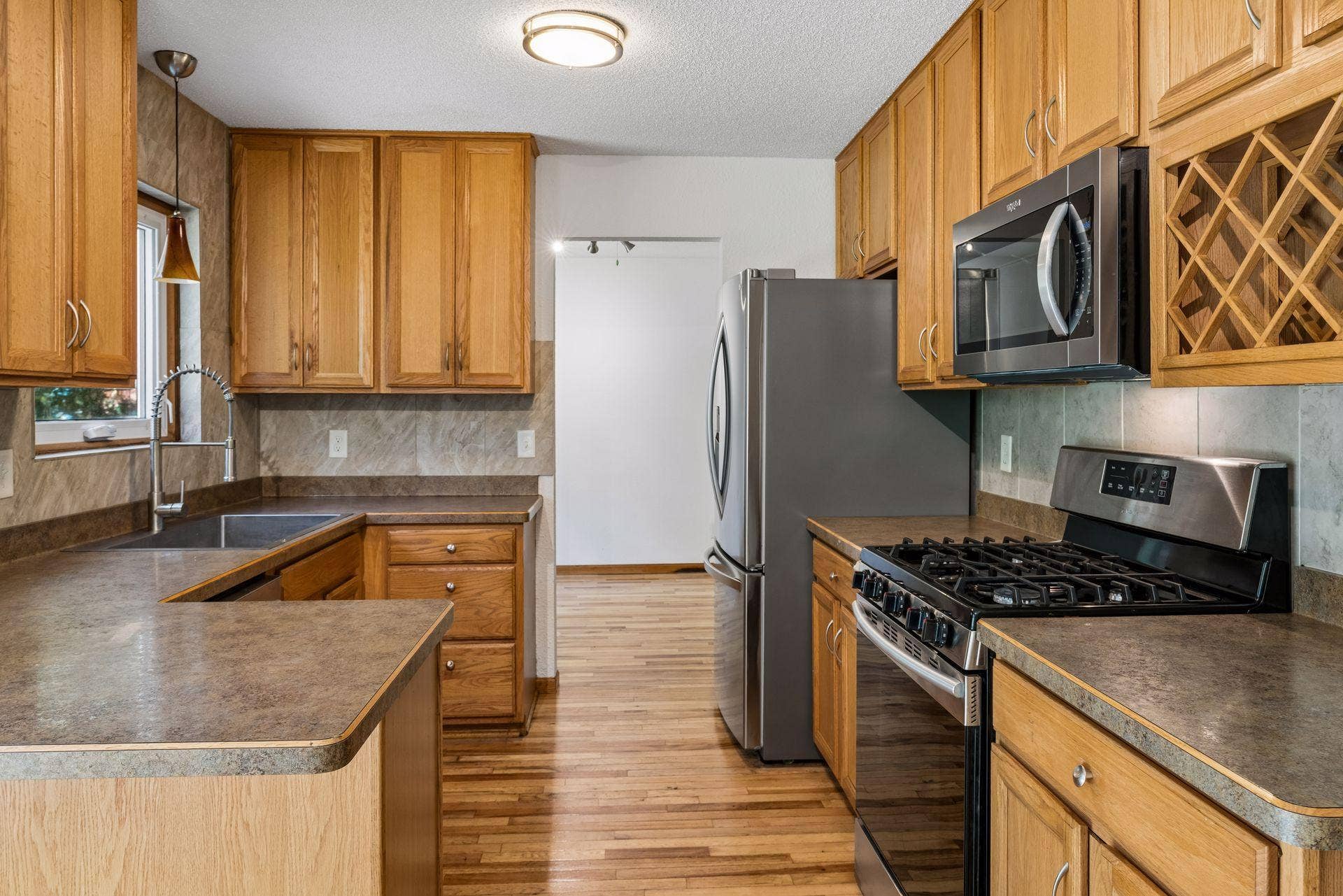 2841 Riviera Drive N, White Bear Lake, MN 55110 Kitchen with hardwood flooring, wood cabinetry, and stainless steel appliances.