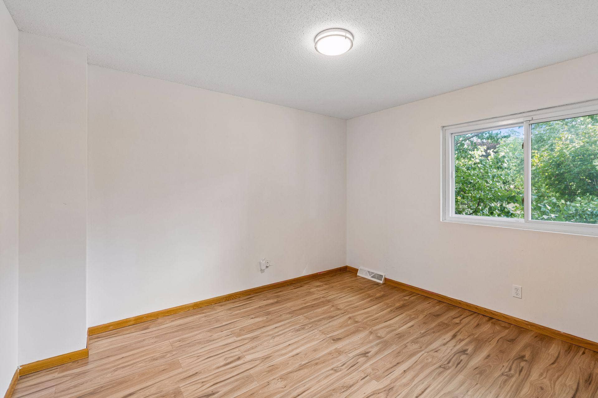 2841 Riviera Drive N, White Bear Lake, MN 55110 Upstairs bedroom three with hardwood flooring and views of mature trees.