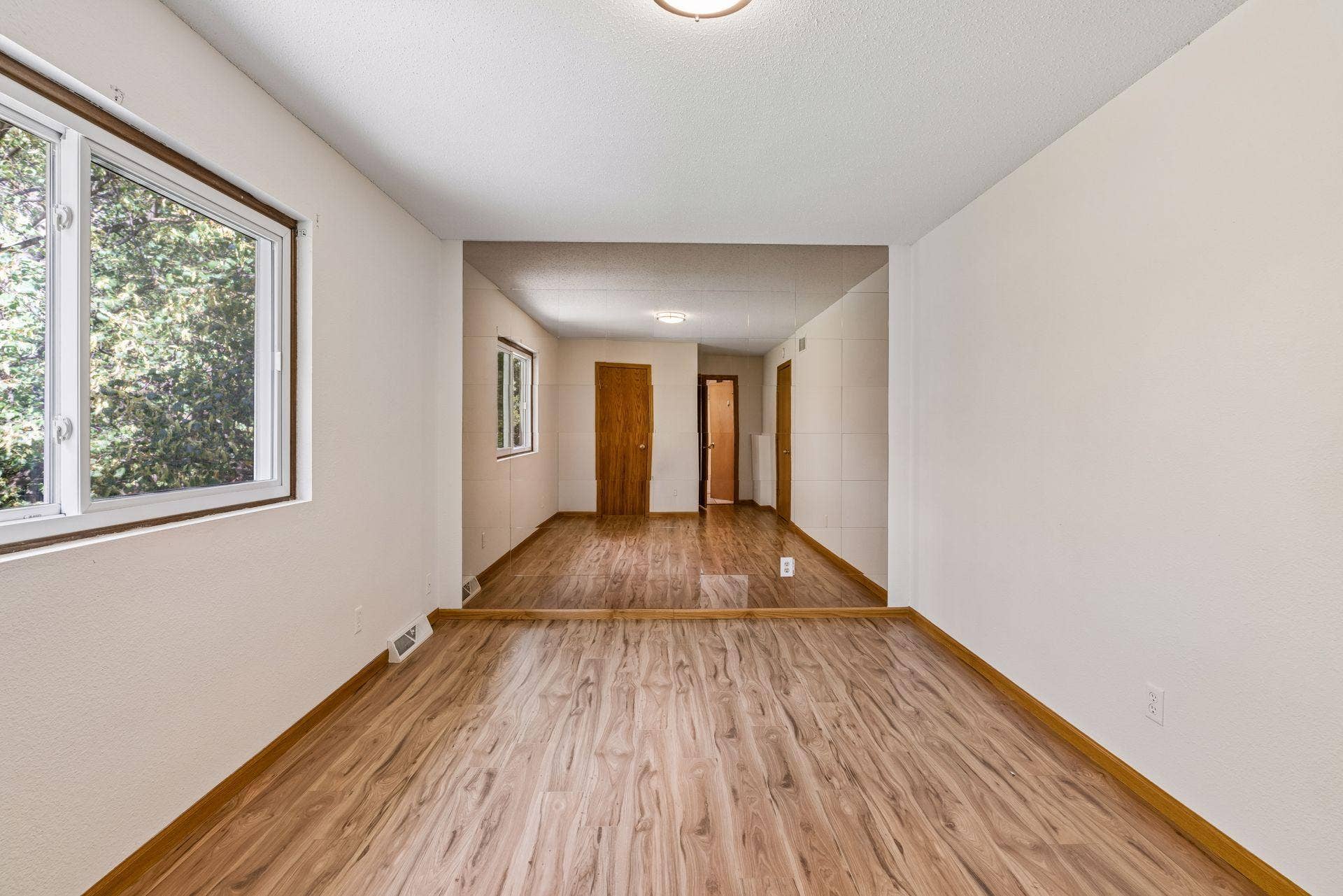 2841 Riviera Drive N, White Bear Lake, MN 55110 Primary bedroom with a large window and mirrored accent wall.
