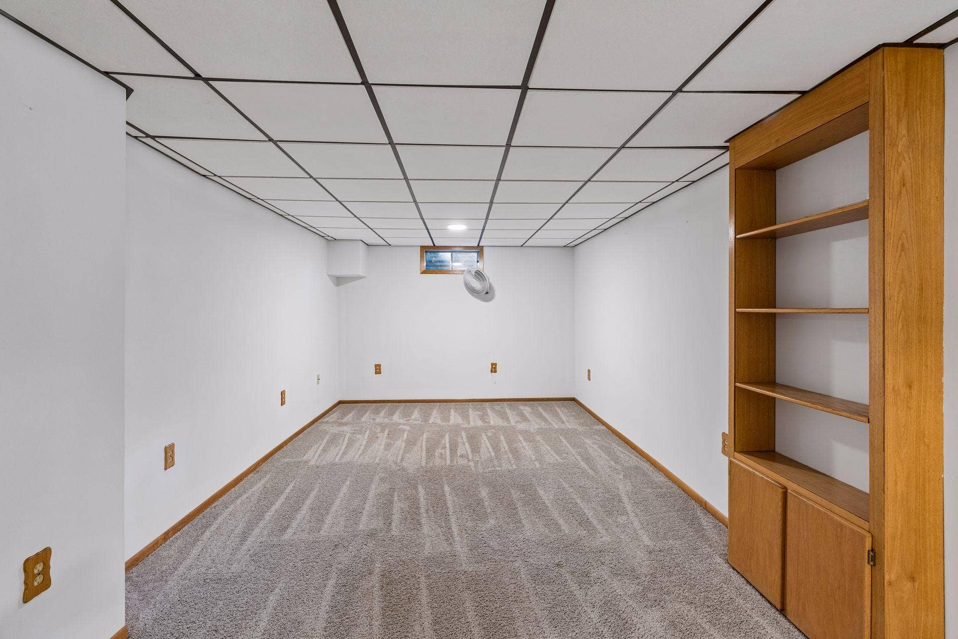2841 Riviera Drive N, White Bear Lake, MN 55110 Lower-level recreation room with built-in shelving and cabinet storage.