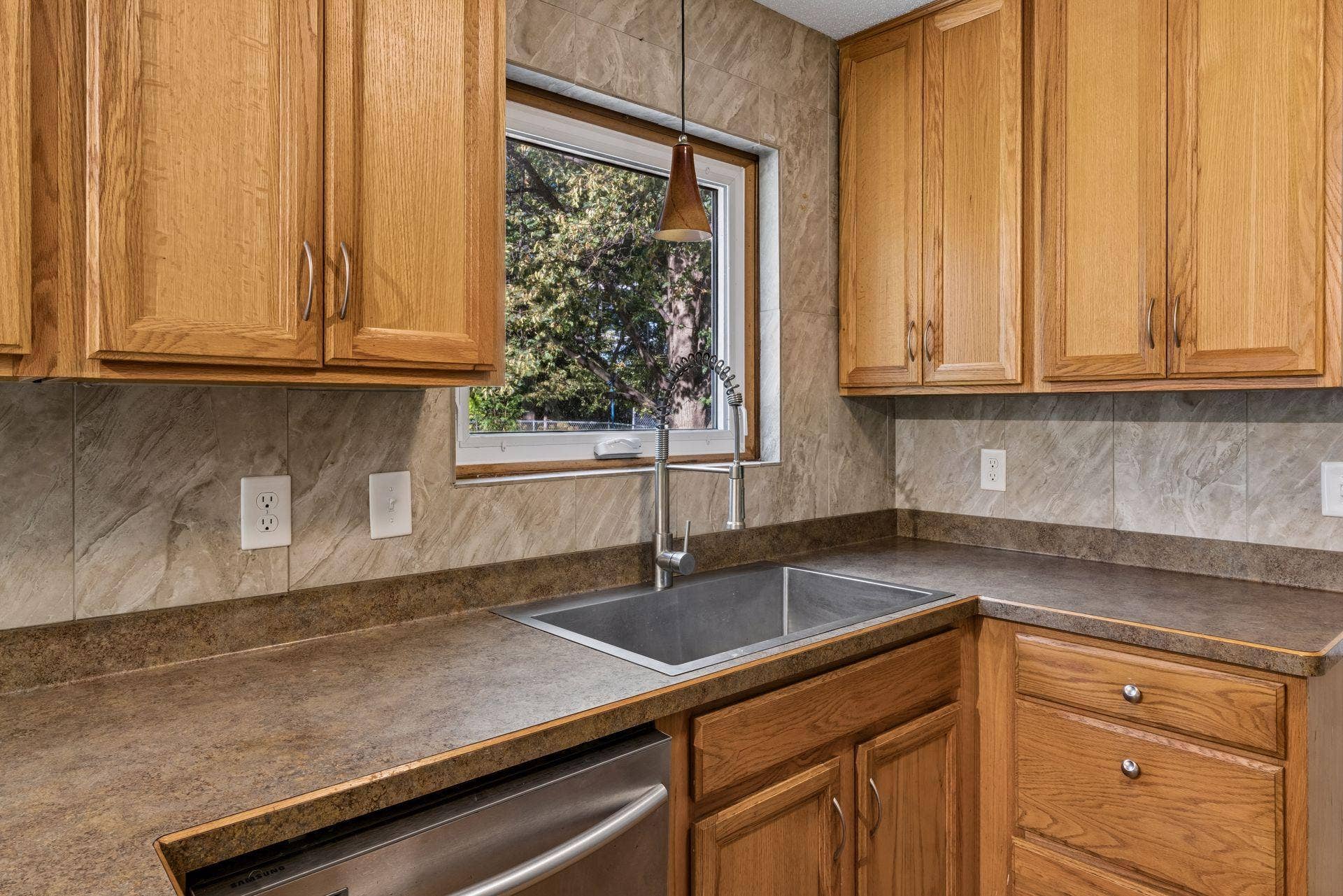 2841 Riviera Drive N, White Bear Lake, MN 55110 Kitchen sink beneath a backyard-facing window, with surrounding counter and cabinet space.