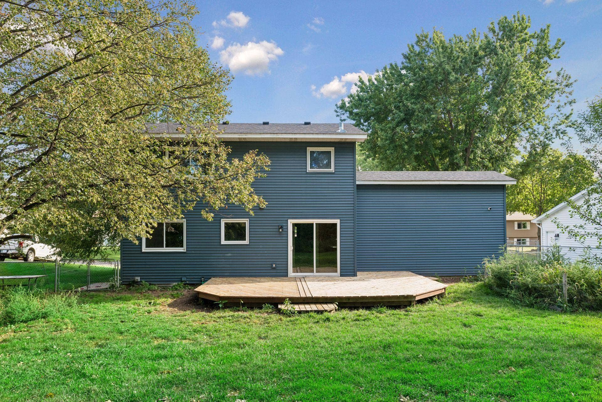 2841 Riviera Drive N, White Bear Lake, MN 55110 Rear exterior with blue siding, white trim, and a broad backyard deck.