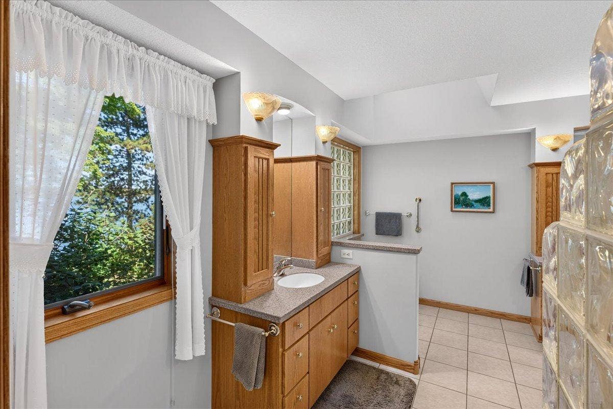 Spacious Bathroom with Dual Vanities, Soaking Tub and Glass Block Details
