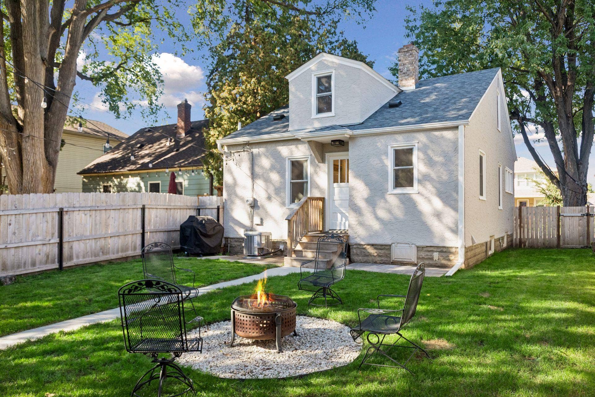 Fully fenced backyard with green space, fire pit area, and new detached two-car garage built in 2024.