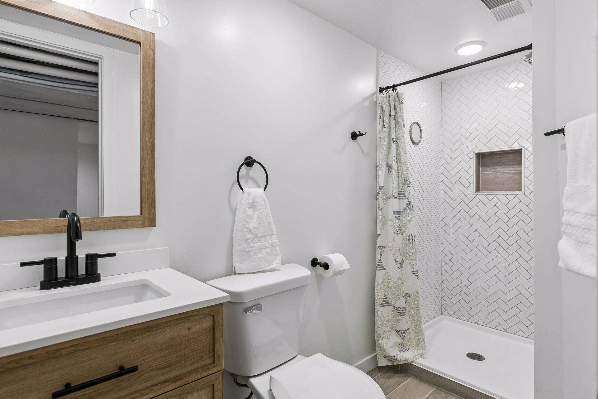 Updated lower-level bathroom with walk-in tiled shower, modern vanity and modern finishes.