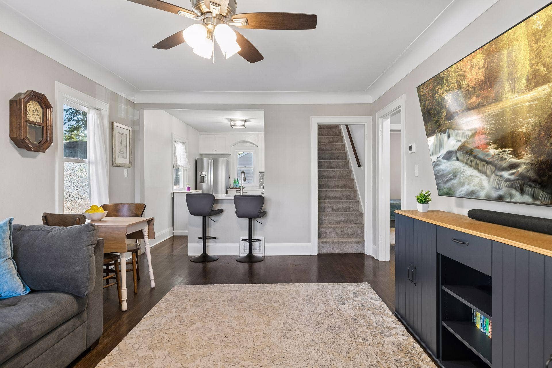 Open view from the living and dining areas toward the modern kitchen, highlighting the functional main-level floor plan and hardwood floors.