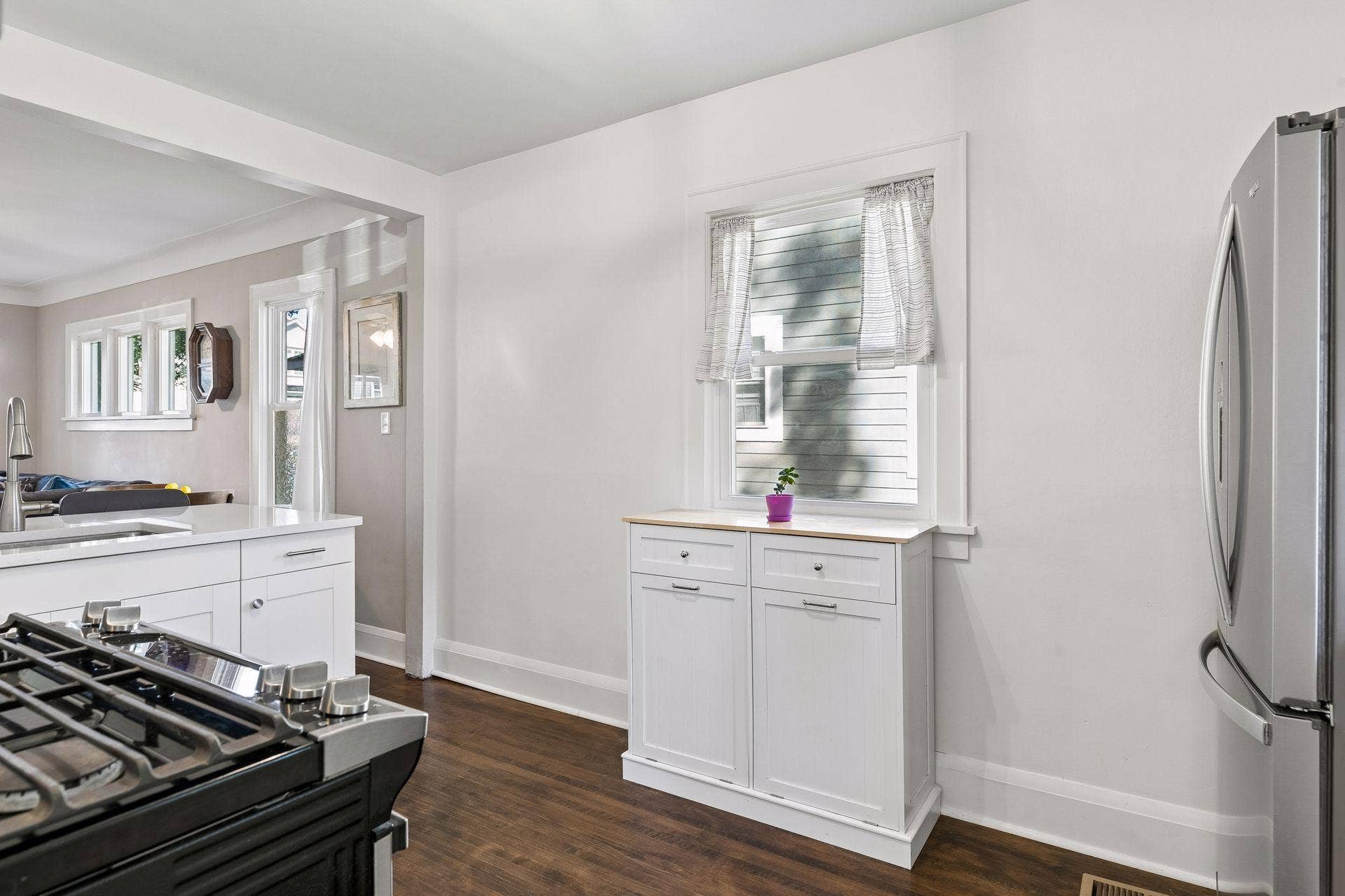 Bright kitchen offers additional cabinetry and storage, stainless-steel appliances, hardwood floors and easy connection to the dining and living areas.