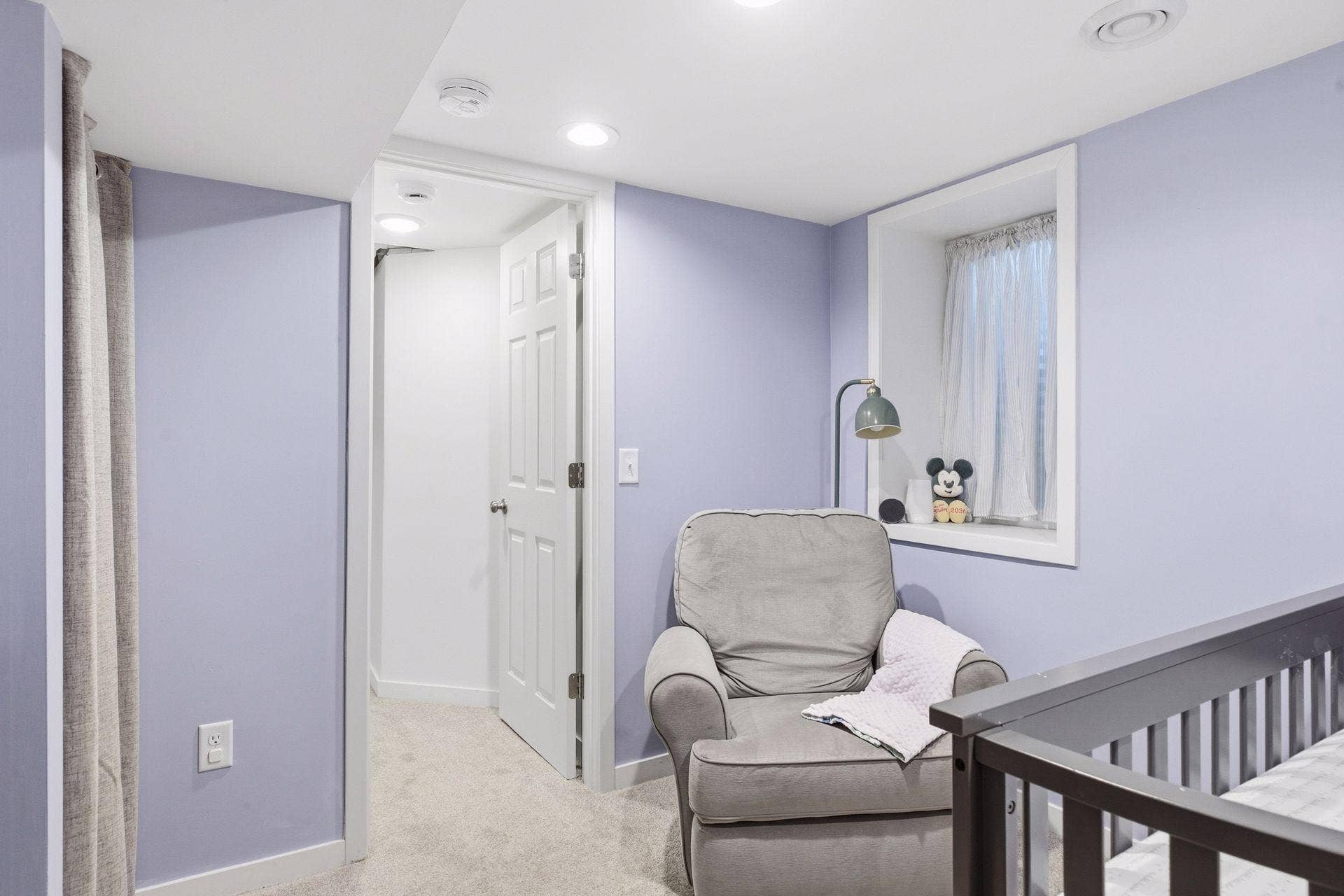 Additional view of the lower-level fourth bedroom with egress window, recessed lighting, and flexible space, currently used as a nursery.