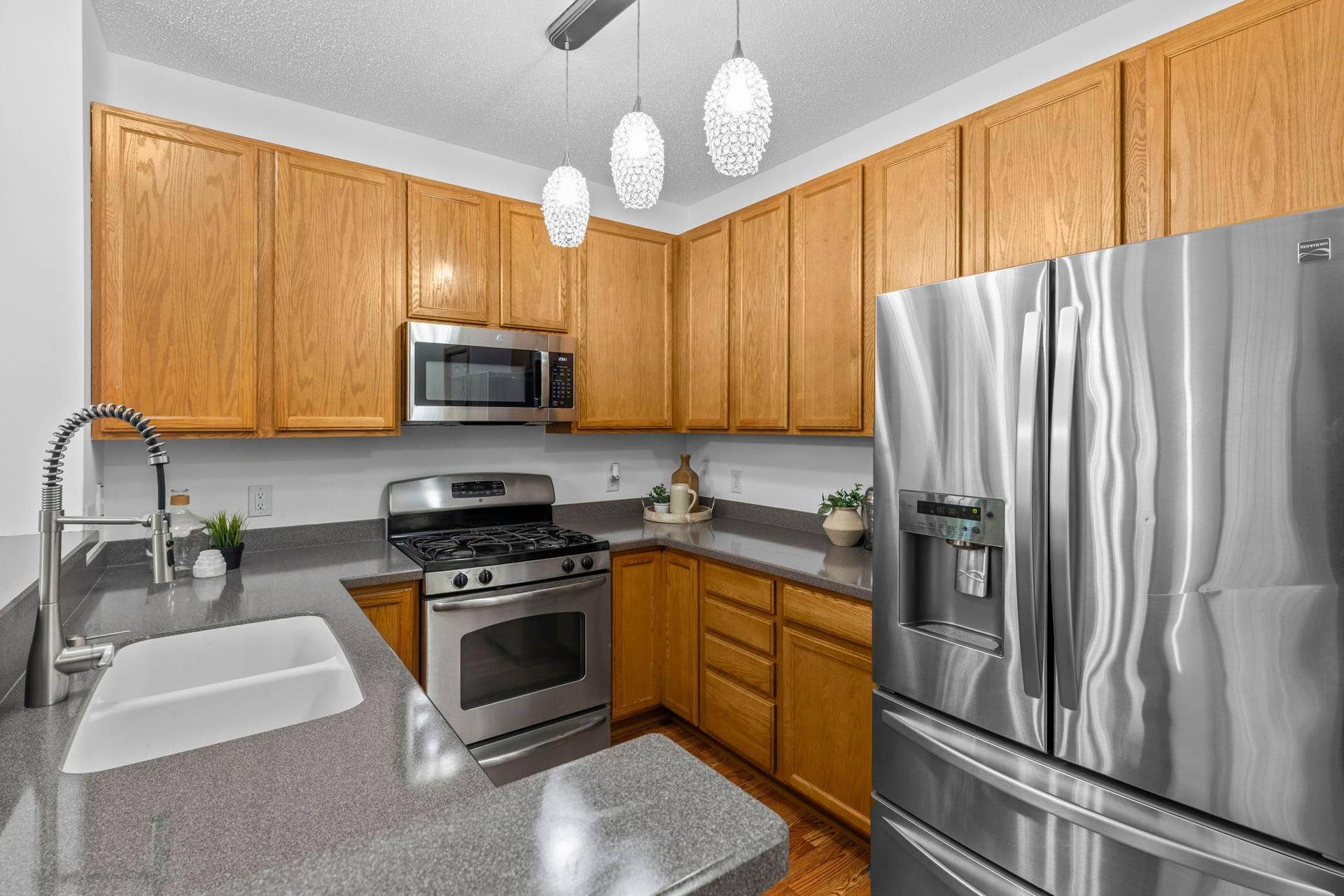 1626 Woodlynn Avenue, #1, Maplewood, MN 55109 The kitchen offers ample cabinetry and counter space, breakfast bar seating, stainless steel appliances, and stylish pendant lighting.
