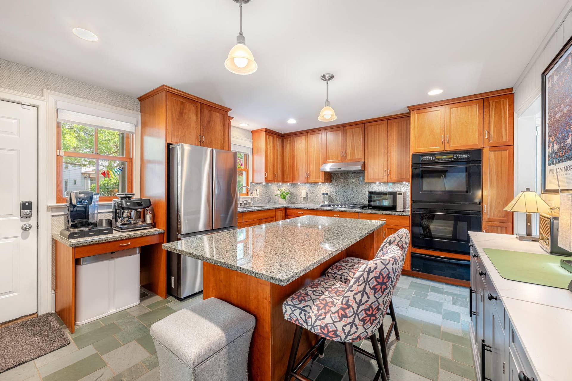 Warm oak cabinets (any plenty of them), large center island with seating, stainless appliances, tile backsplash, double wall oven, and fresh tile flooring.