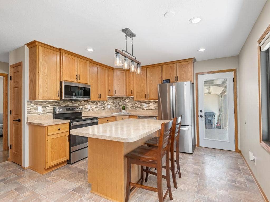 13008 Lakeview Drive Drive, Burnsville, MN 55337 The kitchen features a seating island, stainless-steel appliances, and ample cabinet space.