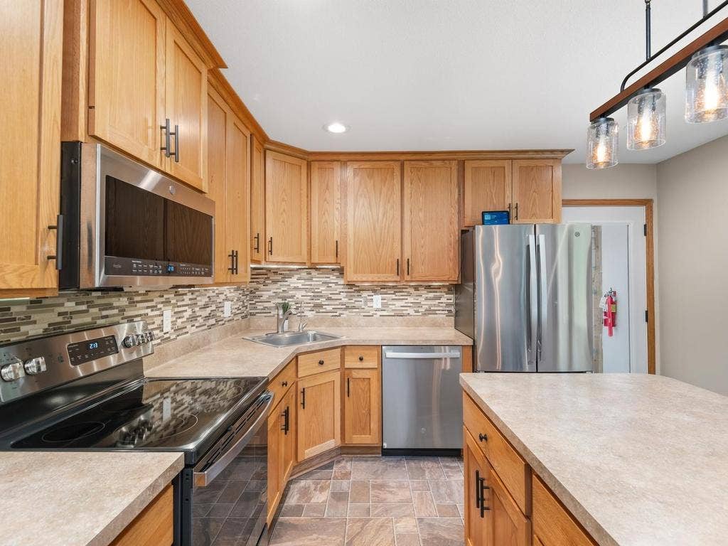 13008 Lakeview Drive Drive, Burnsville, MN 55337 Another view of the kitchens cabinetry, tile backsplash, and generous counter space.