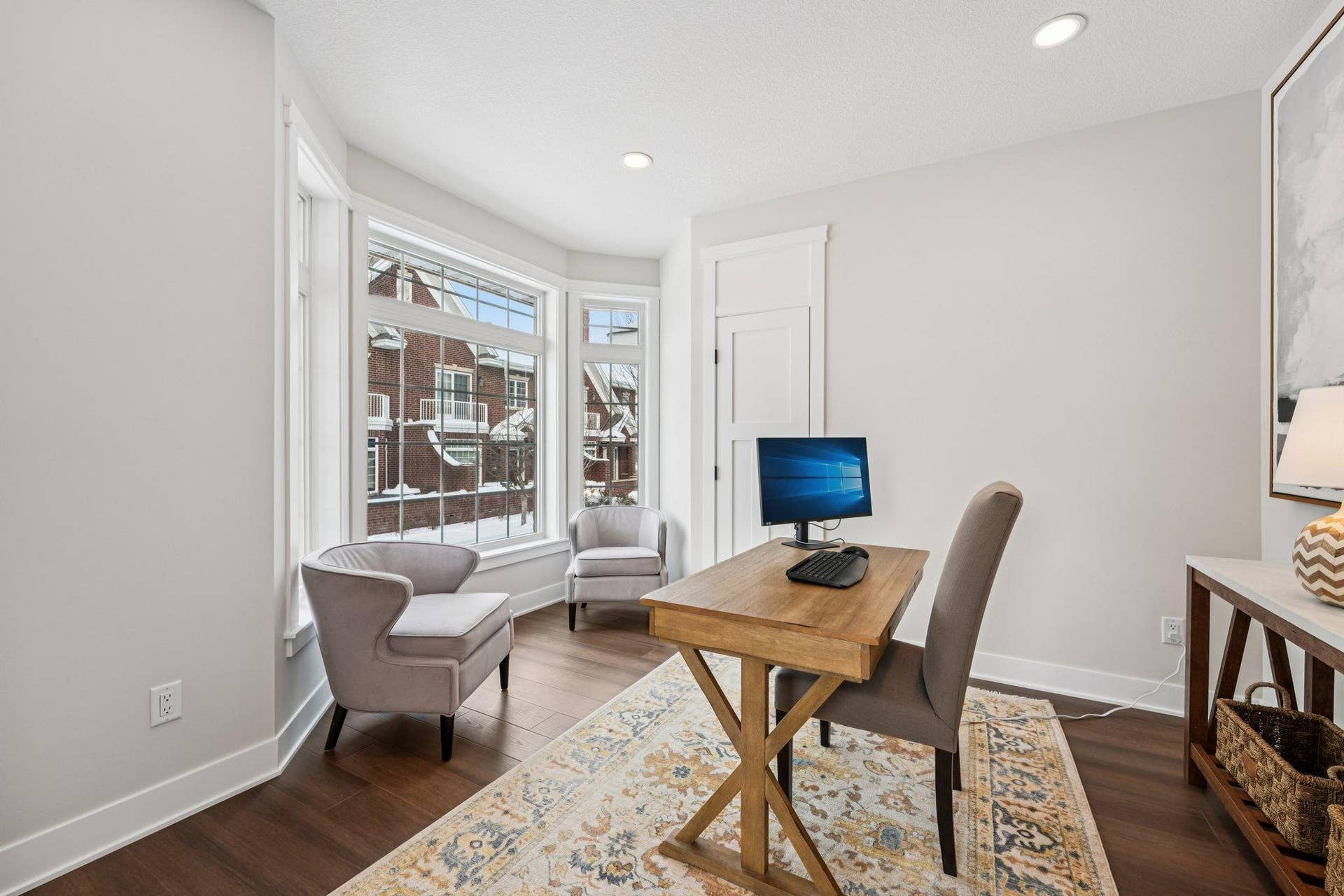 Dedicated home office with large windows, hardwood flooring, and plenty of natural lightideal for remote work or a quiet study space.