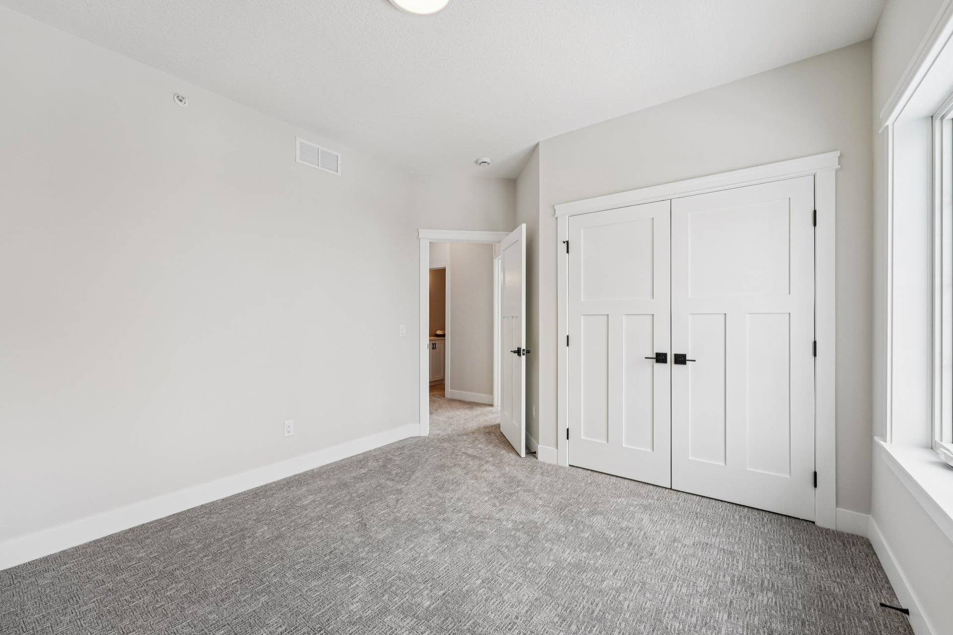 Additional bedroom view highlighting the functional layout, bright windows, and modern trim details.