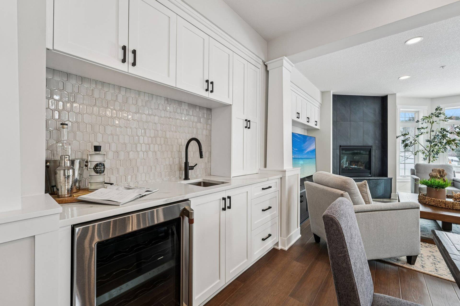 Stylish wet bar featuring a sink, quartz countertop, open shelving, and additional cabinetryideal for entertaining, hosting guests, or creating a dedicated beverage station.
