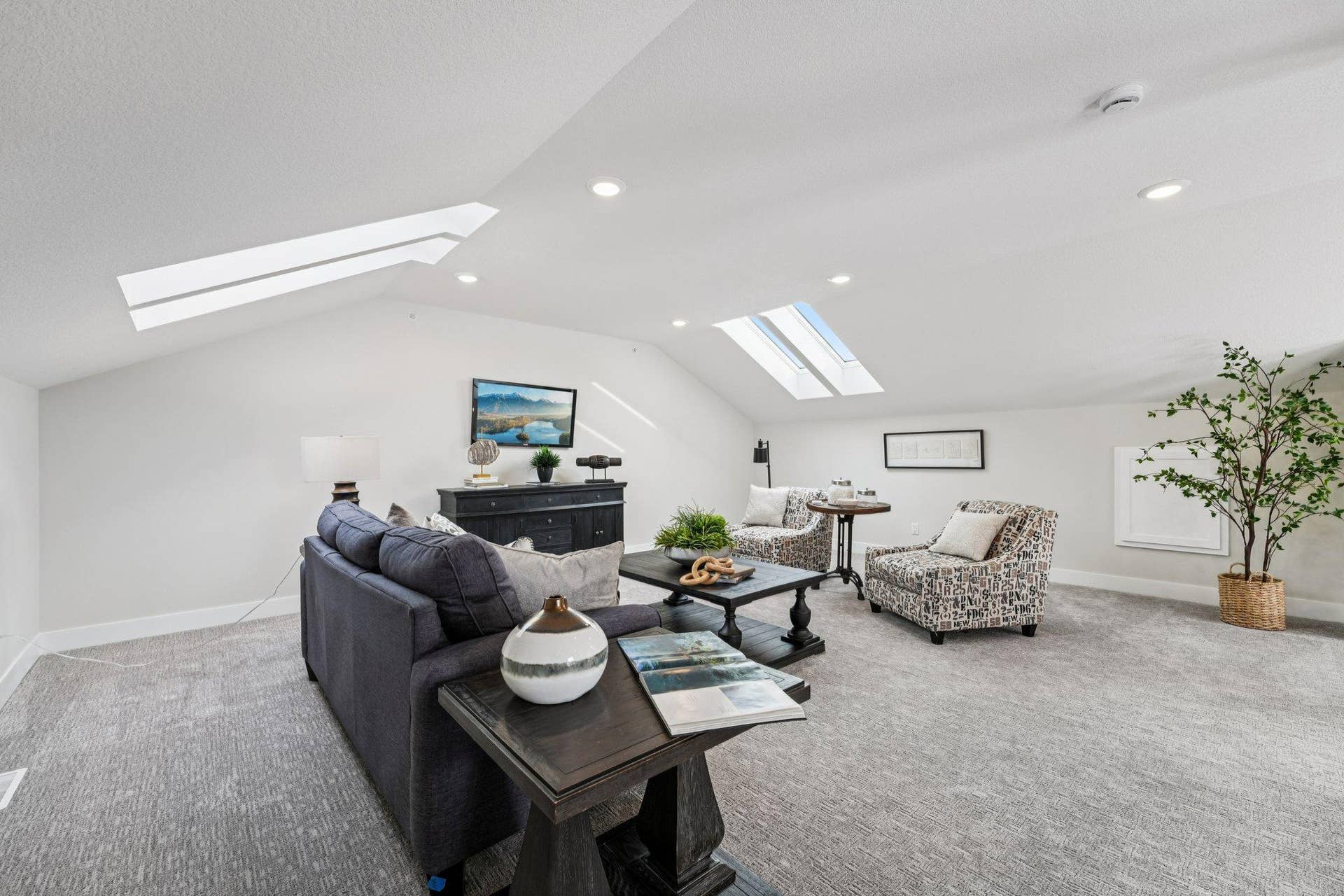 Expansive loft area with vaulted ceilings, skylights, and recessed lightingperfect for a second living space, media room, or flex area.