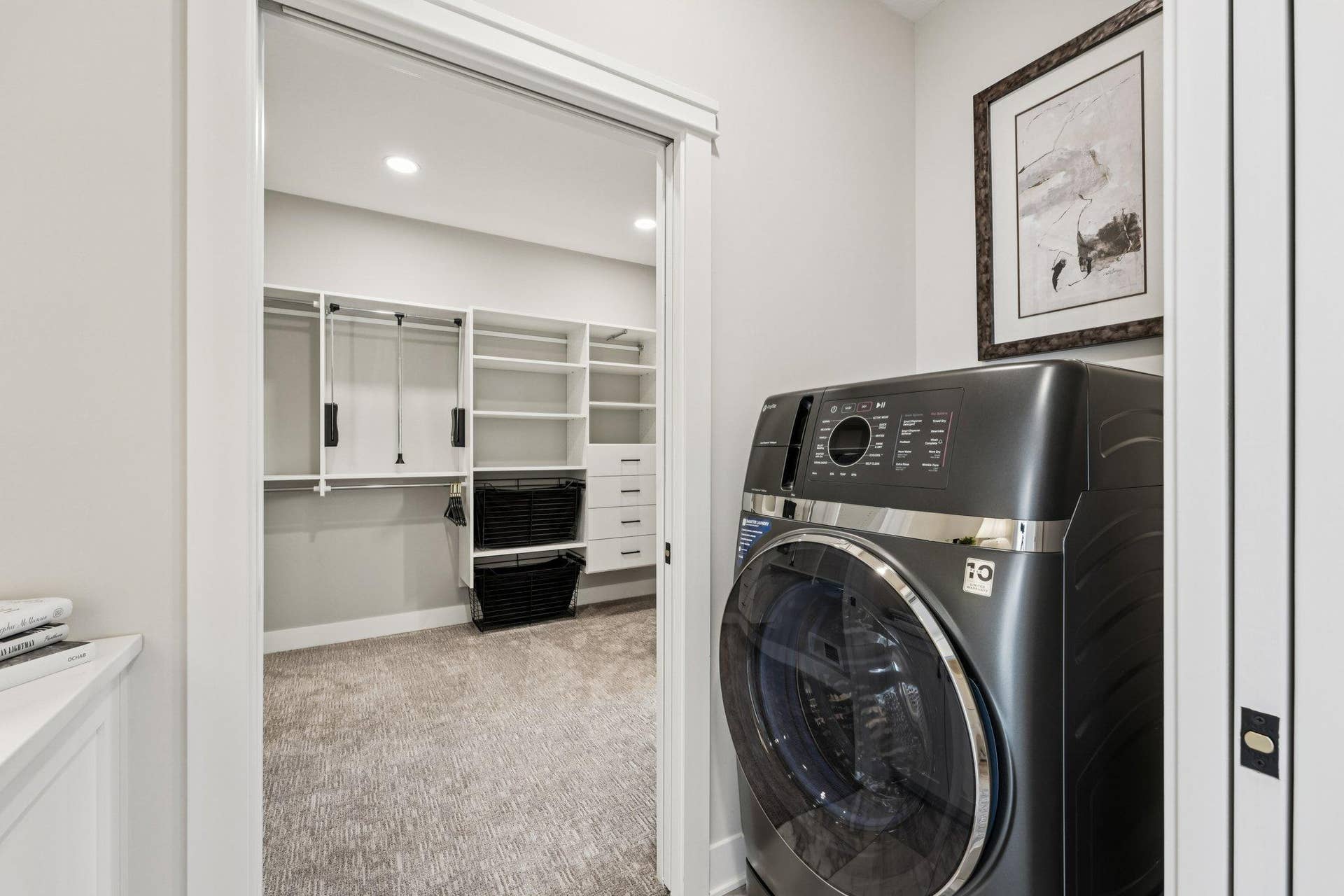 Convenient laundry room with front-load washer and dryer, adjacent to a spacious walk-in closet with custom shelving and organization.