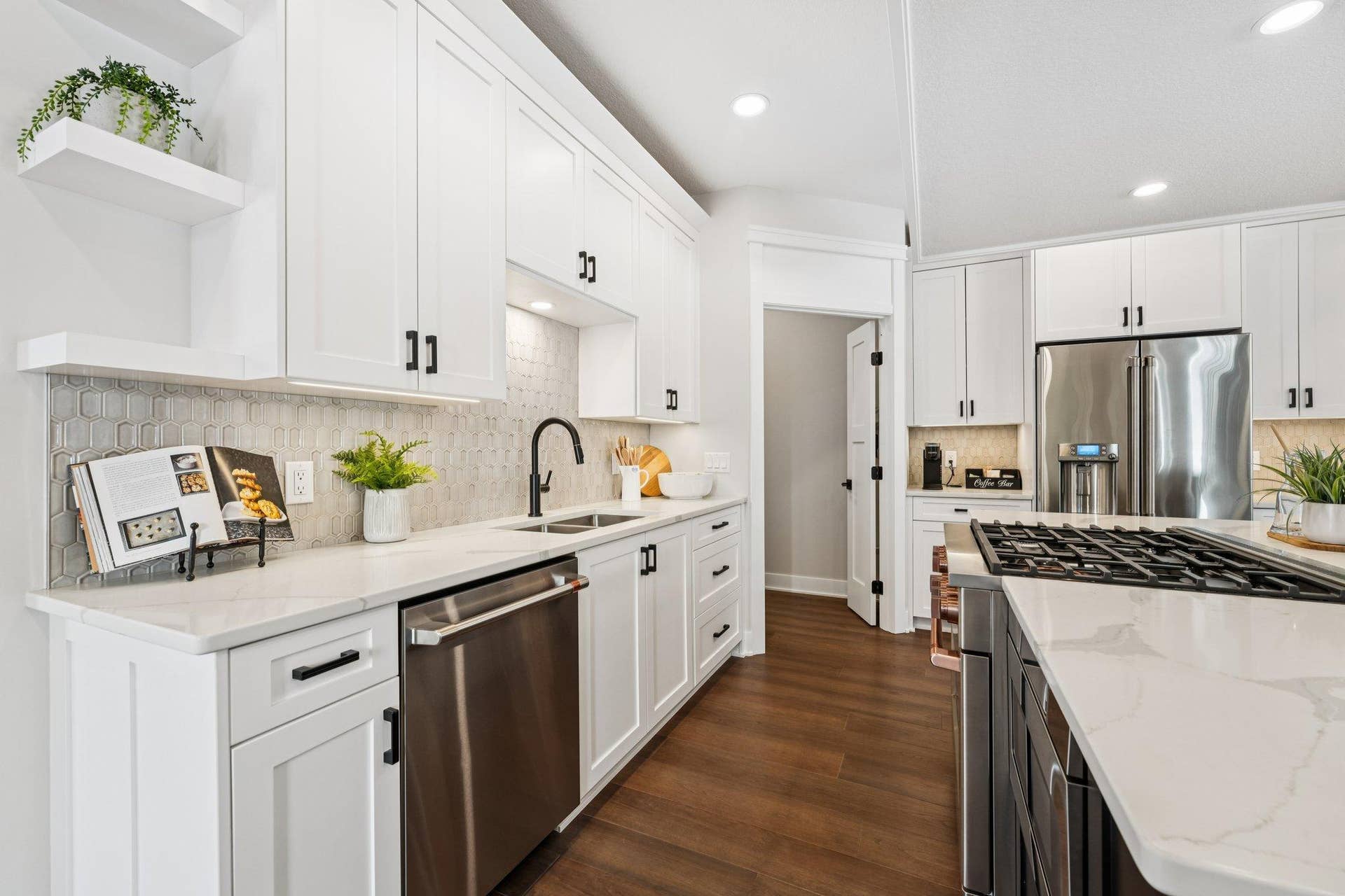 Bright kitchen workspace with white cabinetry, sleek hardware, tile backsplash, and generous counter space designed for both function and style.