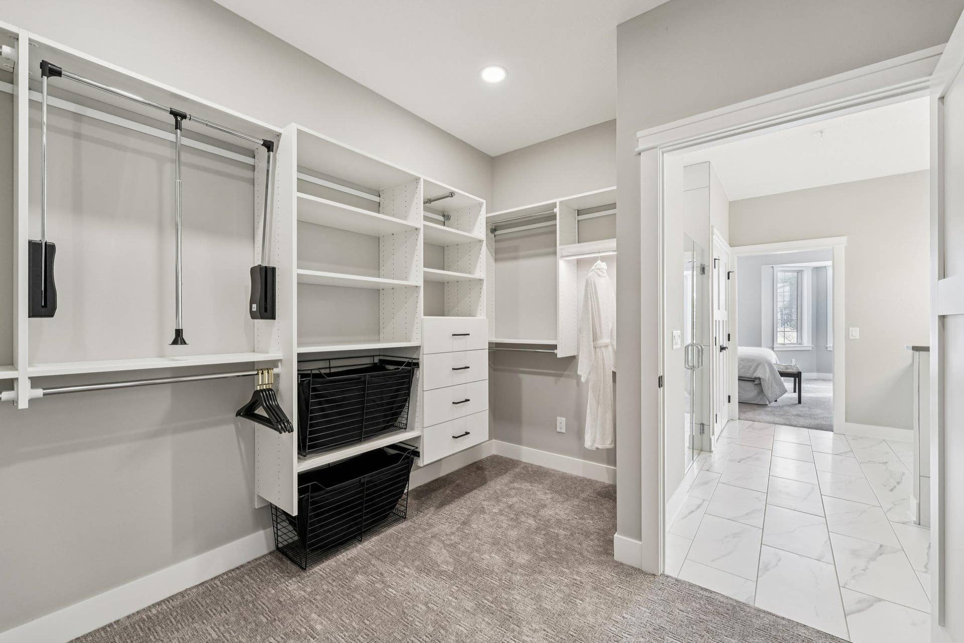 Spacious walk-in closet with custom shelving, drawers, and hanging spacedesigned for organization and convenience.