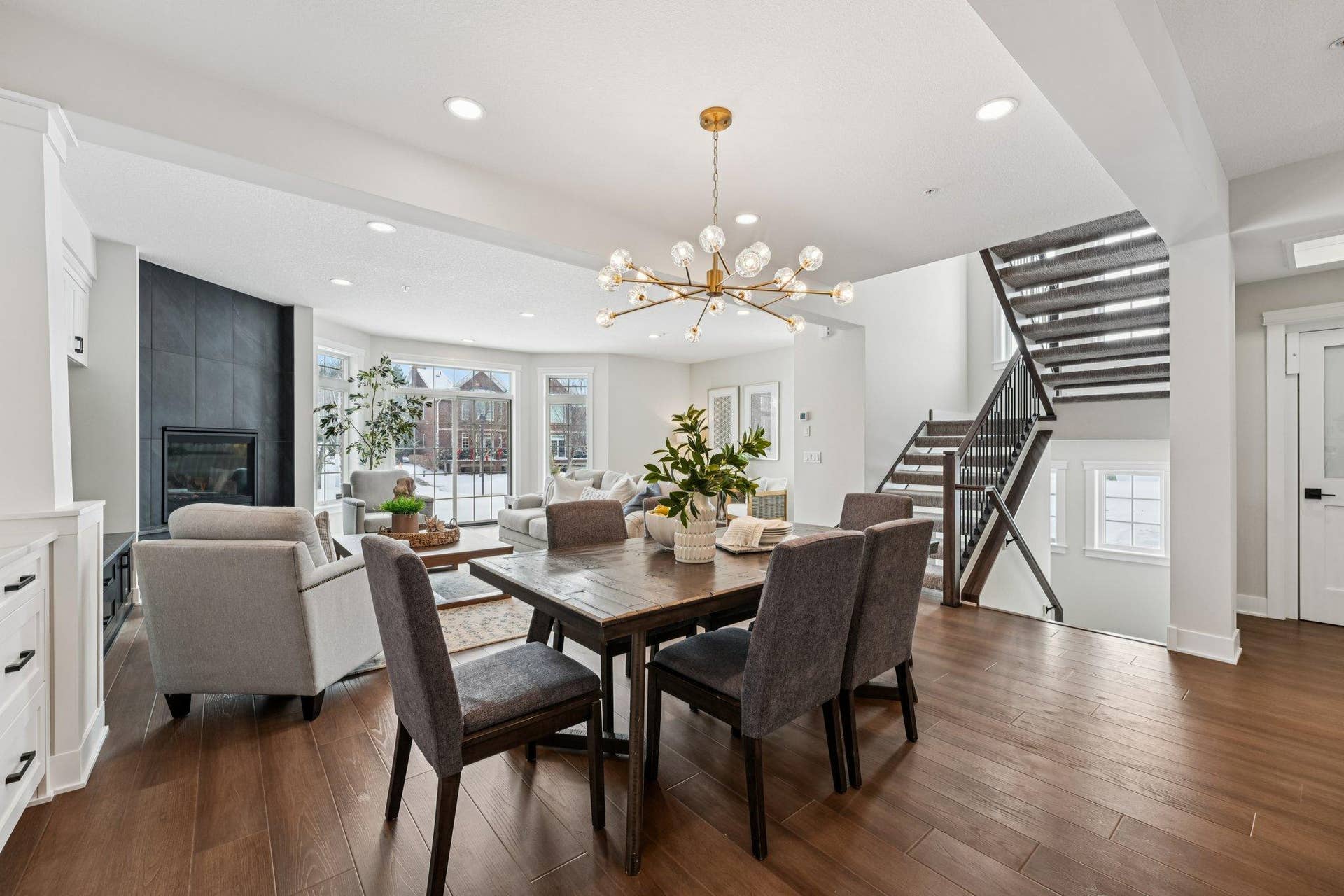 Dining space framed by modern lighting and open staircase, highlighting architectural detail and thoughtful layout.