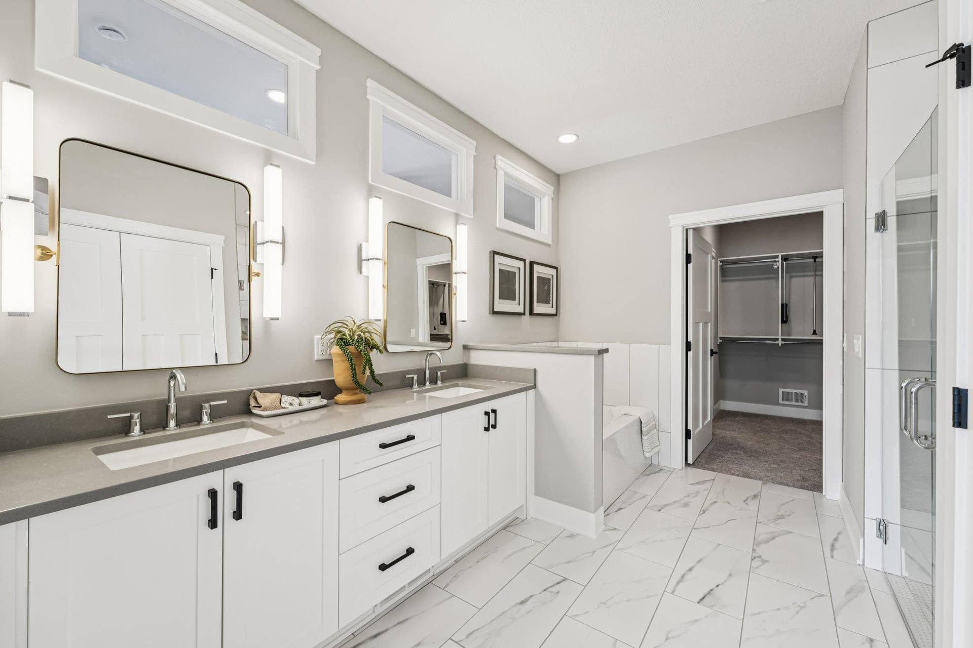 Primary bathroom featuring a dual-sink vanity with quartz countertops, modern fixtures, and ample storage for everyday functionality.